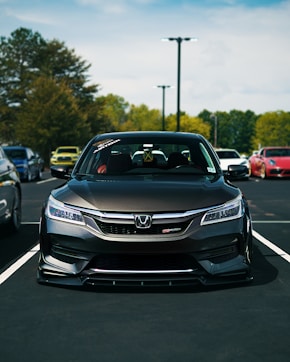 A modified honda accord is parked in a lot.