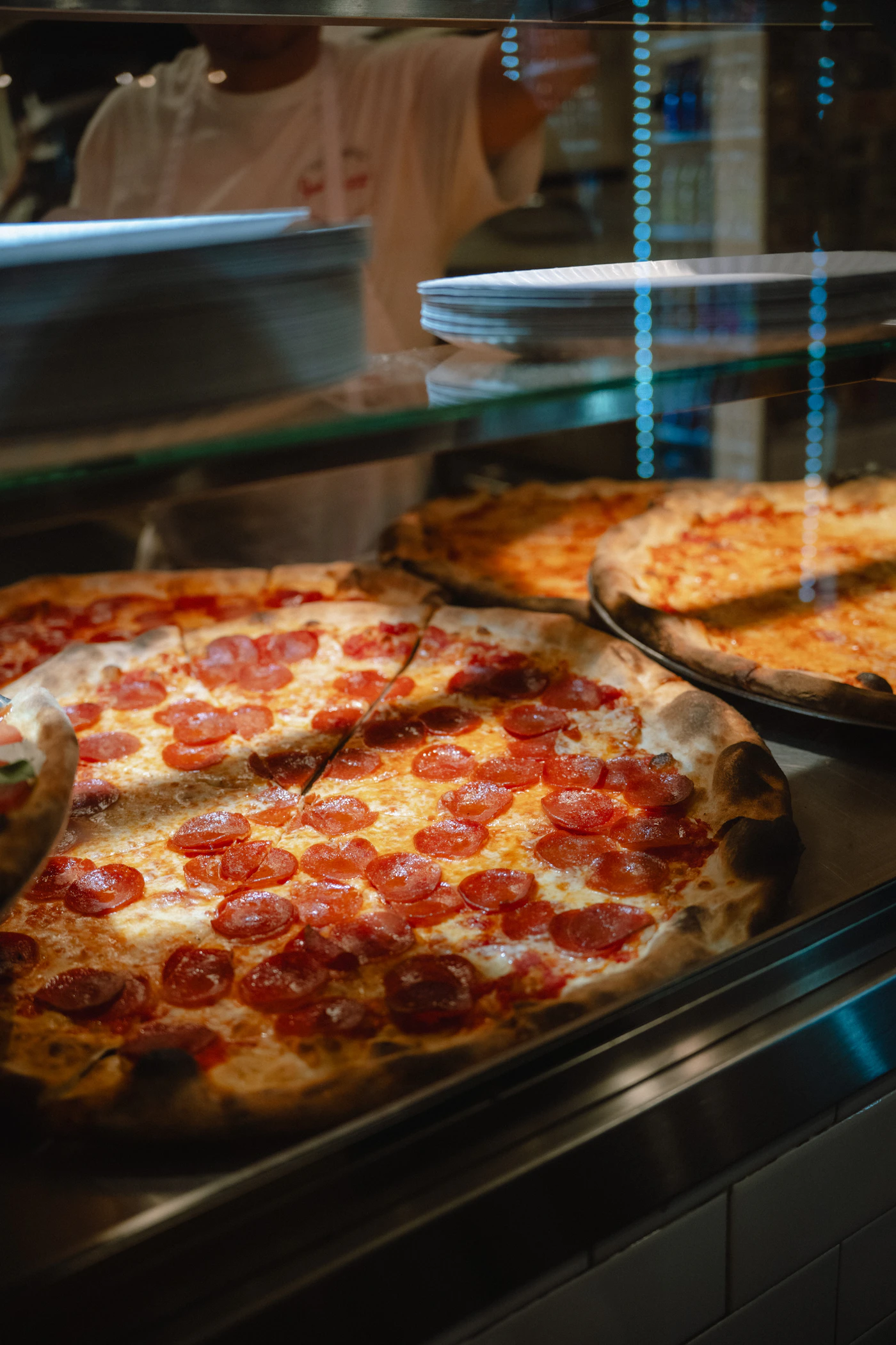 Authentic New York pepperoni pizzas at a city pizzeria counter