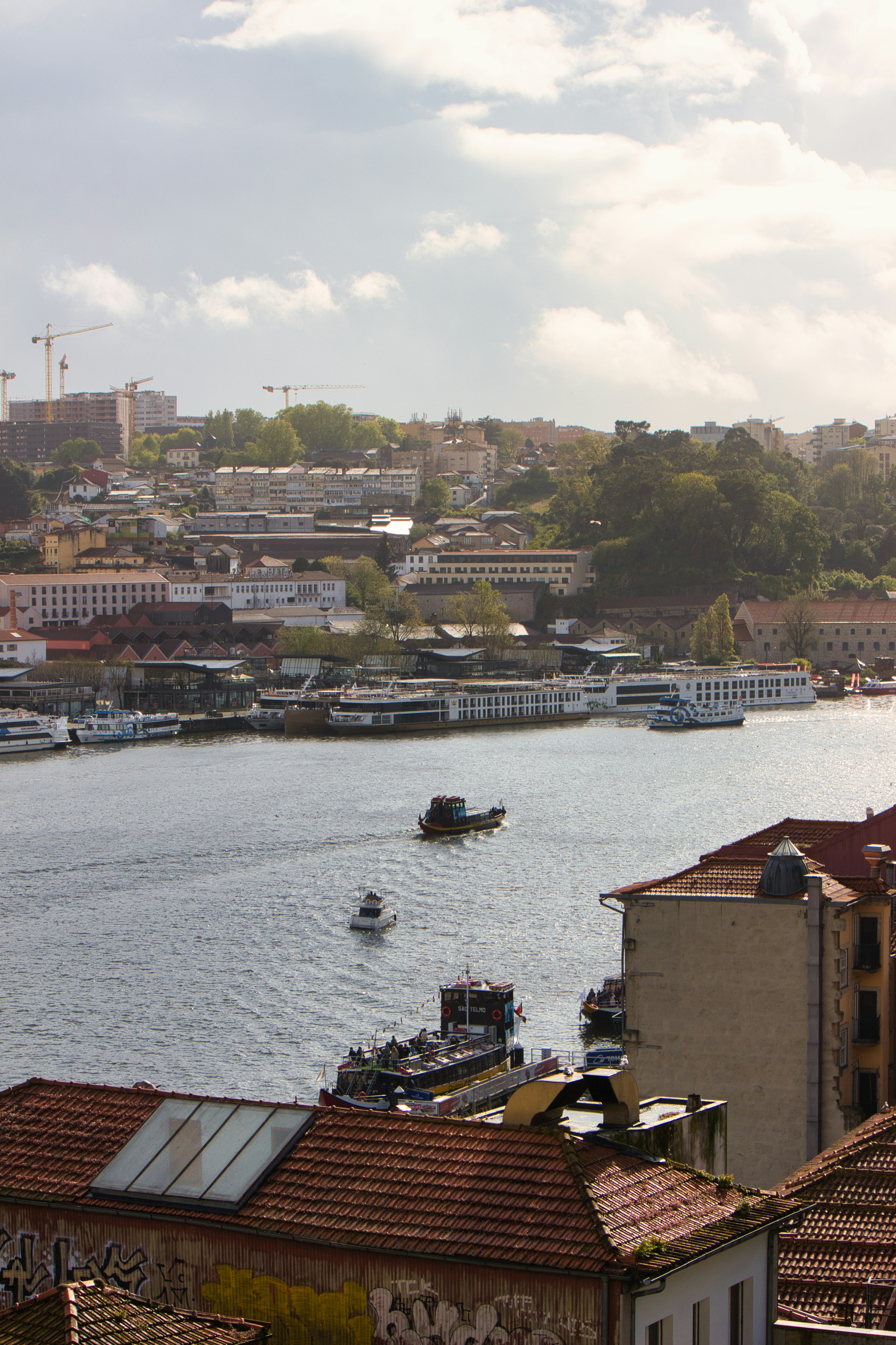 A cityscape overlooks a river with several boats.