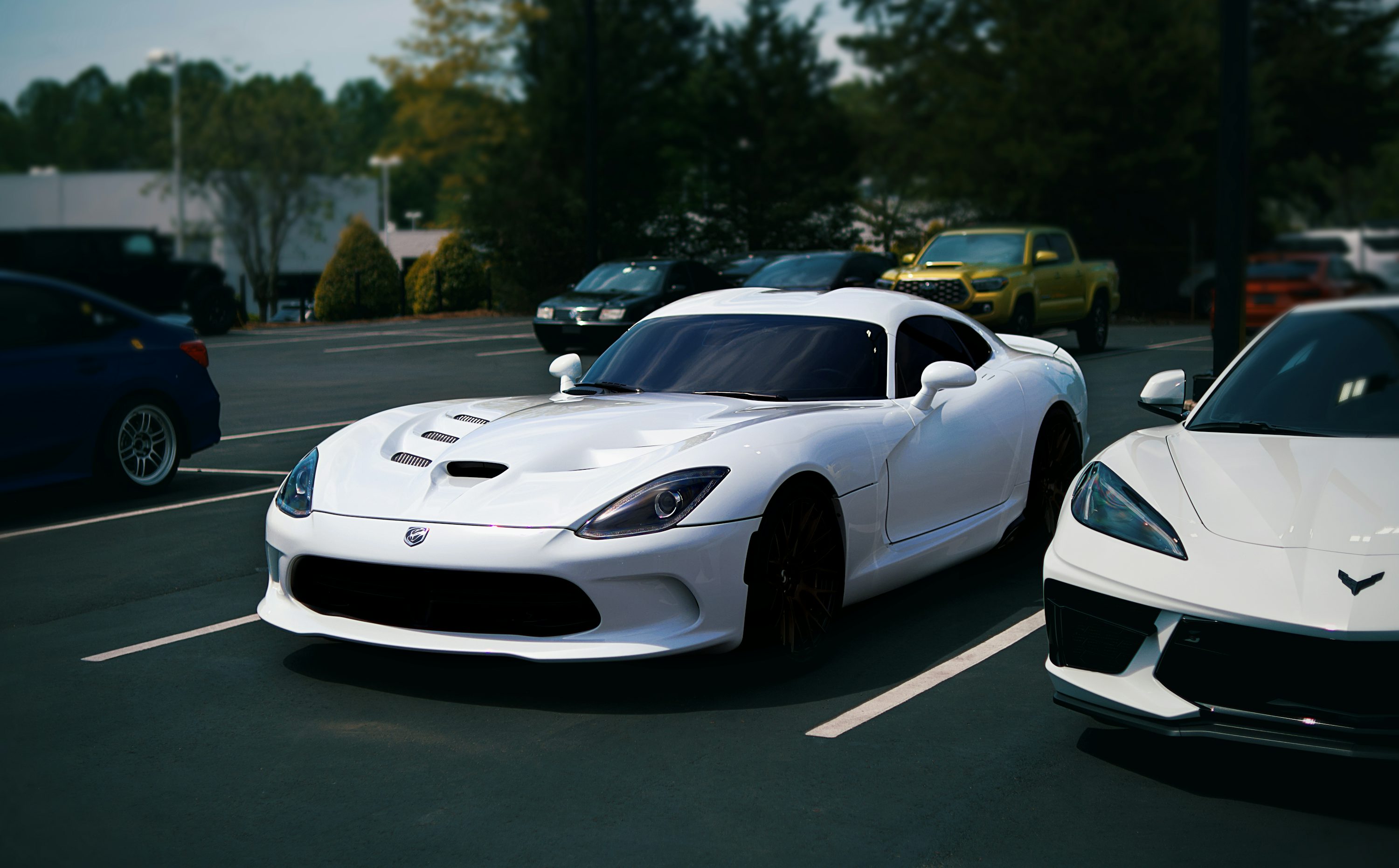 White sports cars are parked in a lot.
