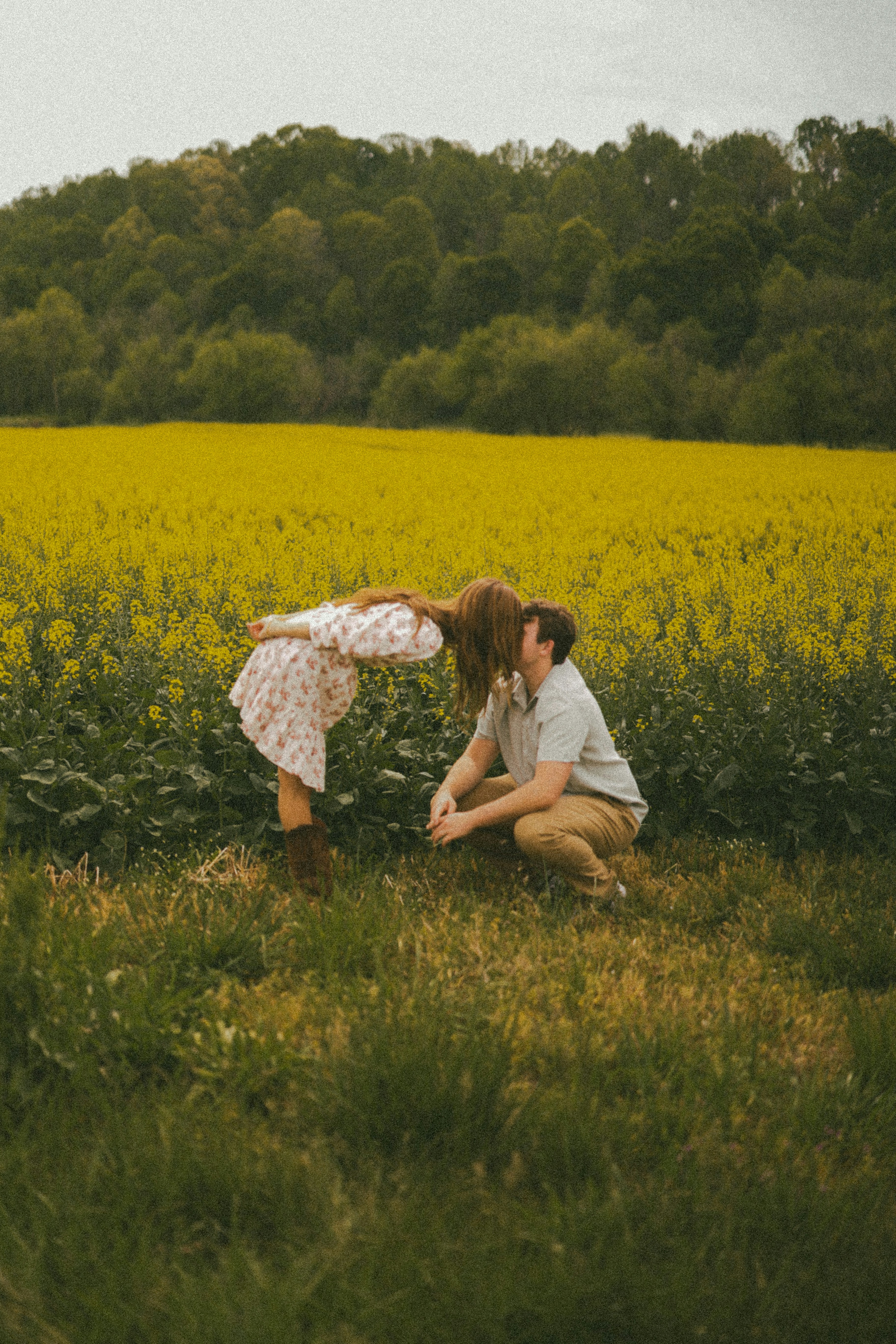 A couple is about to kiss in a field.