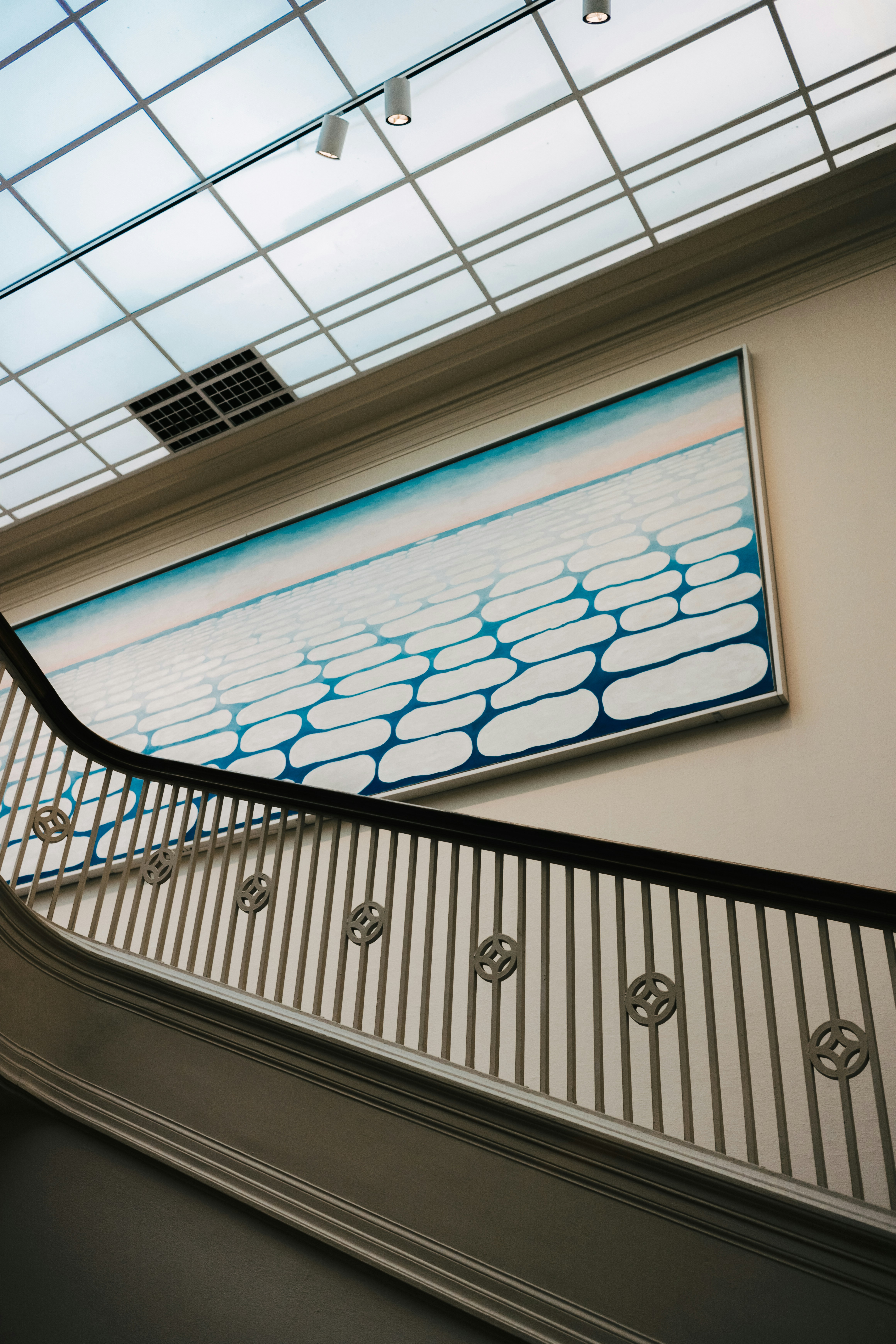 Art and stairs are seen in a museum.