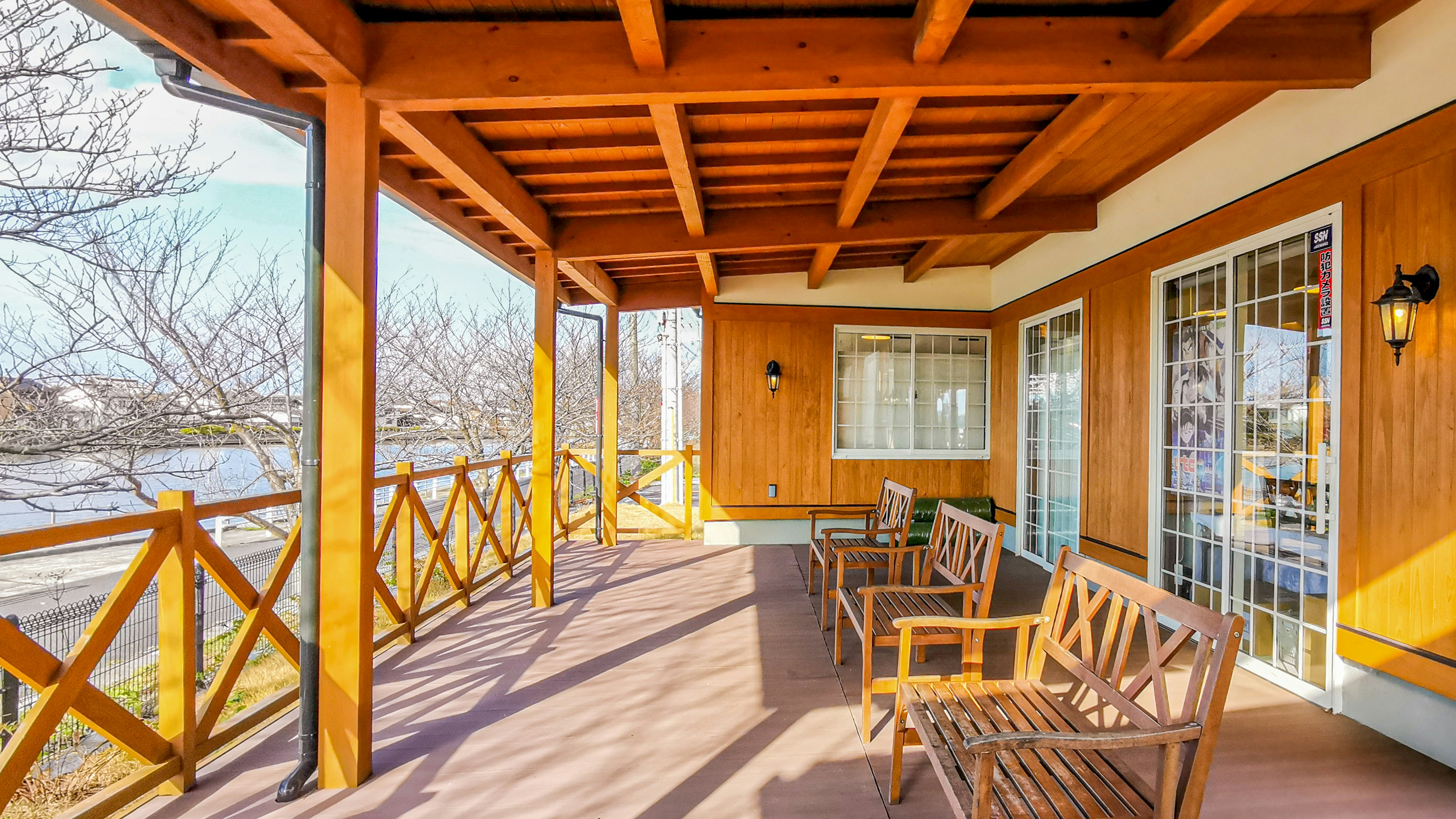 A cozy wooden porch is shown with furniture.