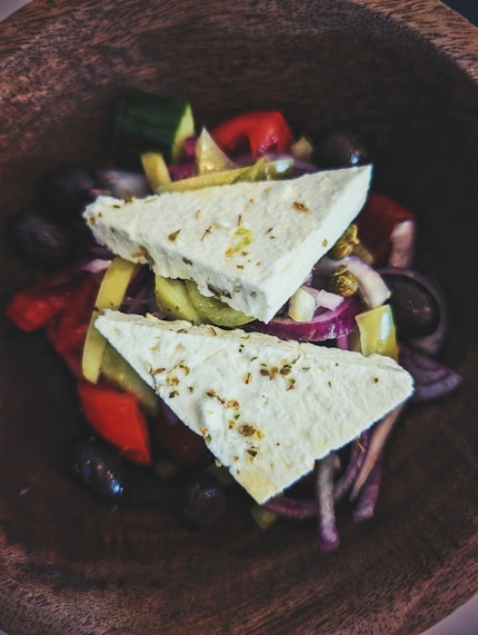 Greek salad with feta cheese in a wooden bowl.