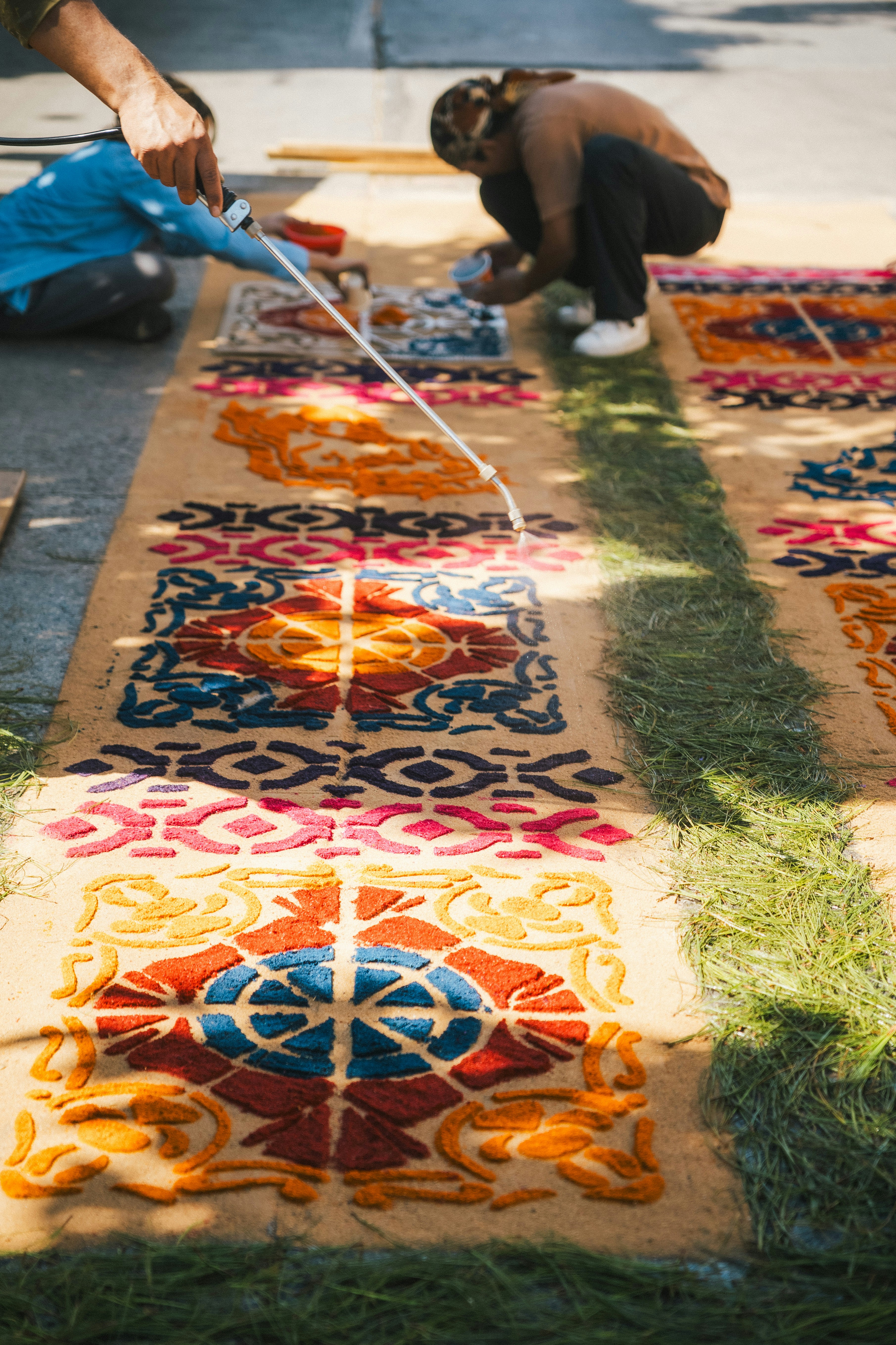 People create colorful carpets on the ground.