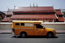 Yellow truck parked in front of a temple