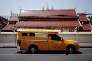 Yellow truck parked in front of a temple
