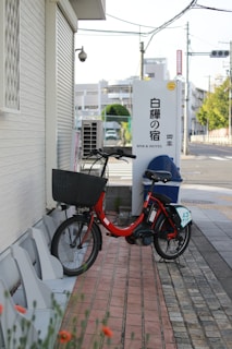 A red bicycle parks beside a japanese inn.