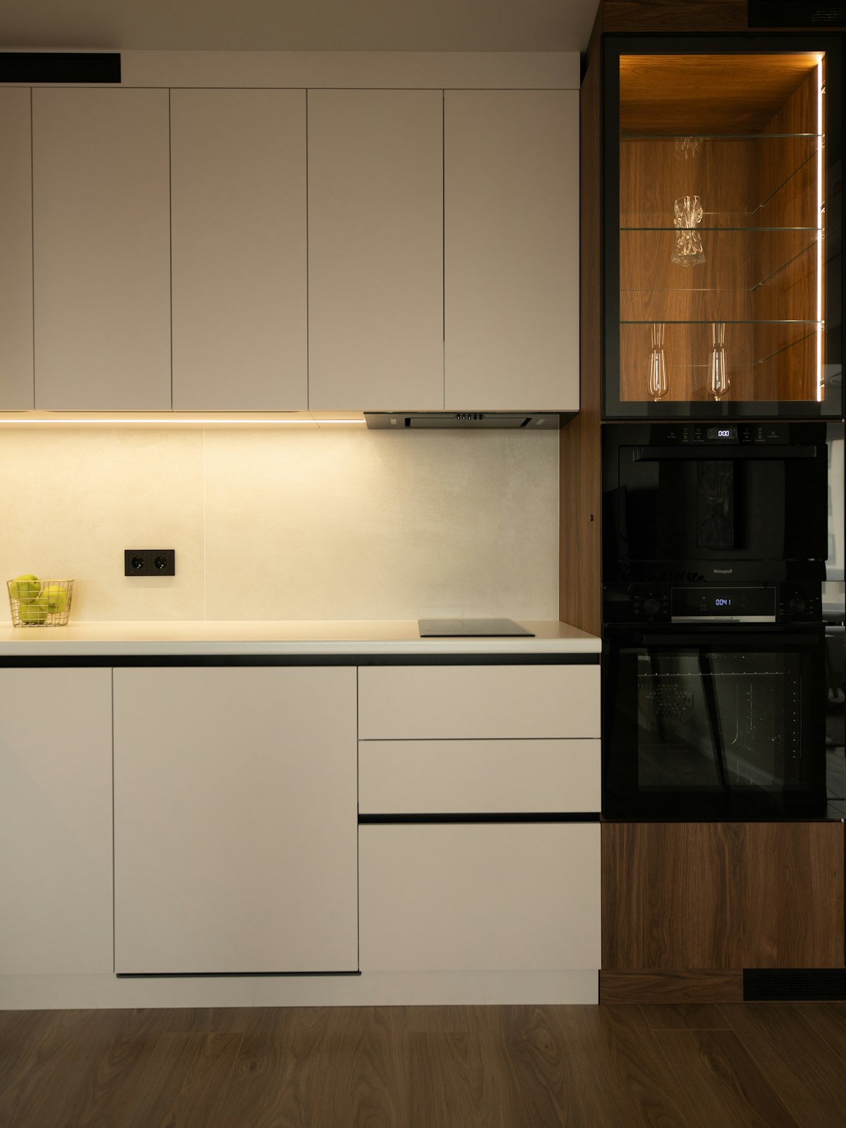 Modern kitchen interior with white cabinetry, black stainless steel appliances, and an open-concept layout
