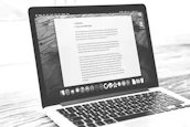 Laptop displays a document, possibly a letter.