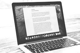 Laptop displays a document, possibly a letter.