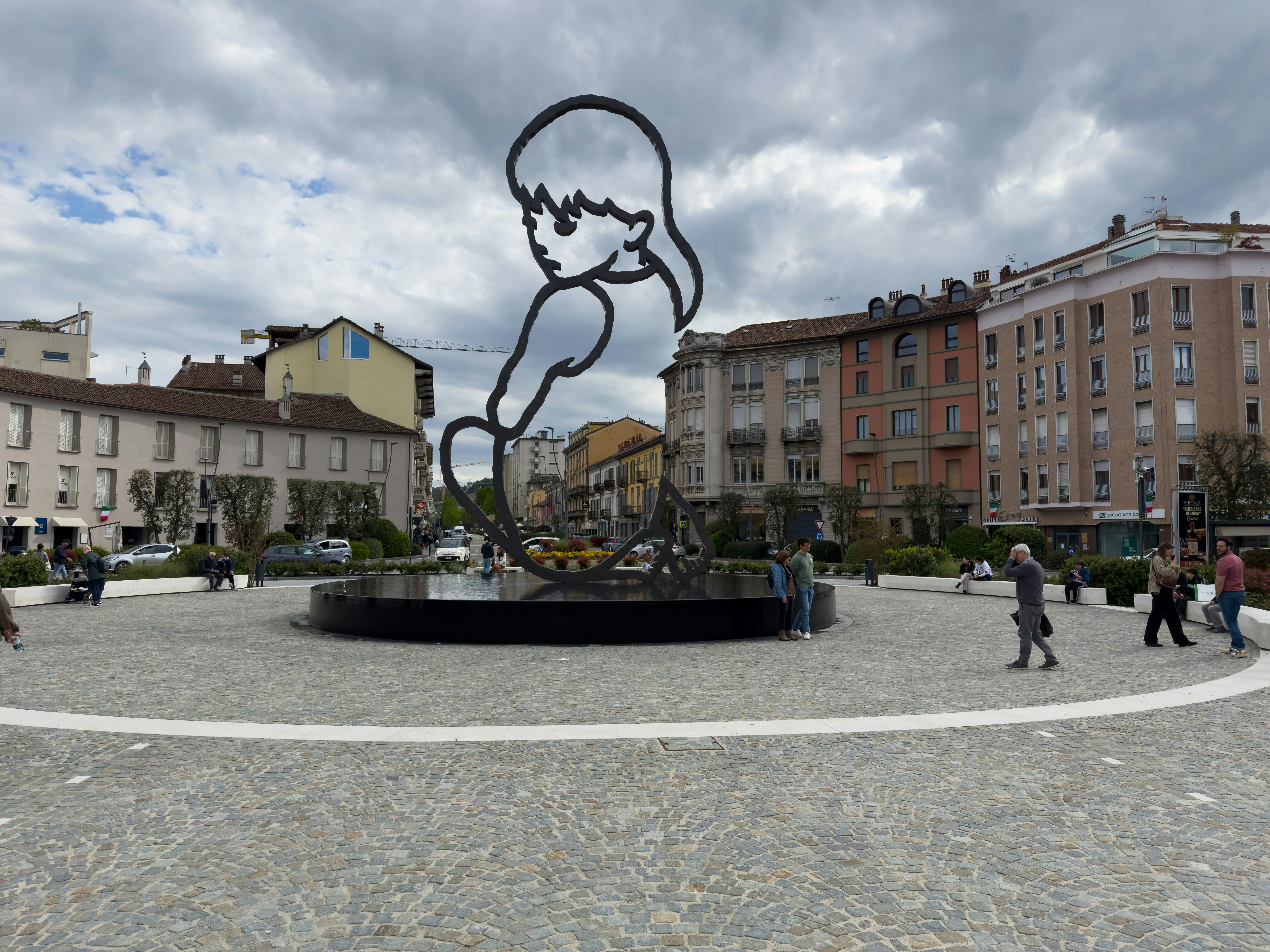 Alba's main square, with a fountain and a sculpture of a little girl.