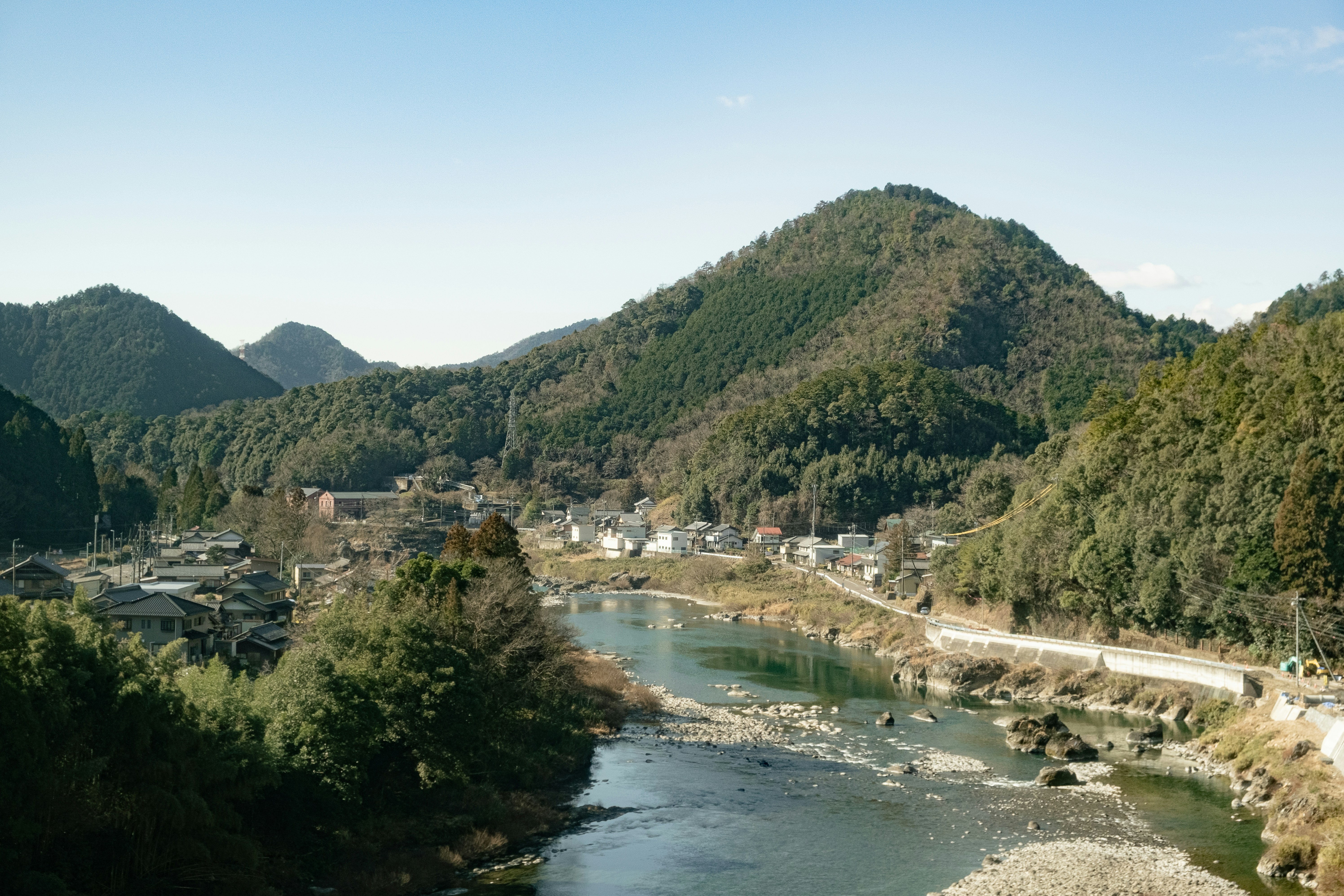 Mountains and a river frame a japanese village.