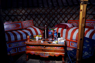 Inside of a decorated yurt with furniture.