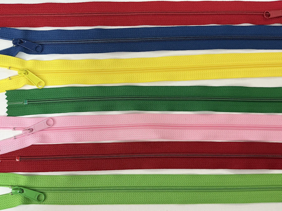 Close-up of colorful zipper pulls and metal teeth, the kind of hardware saltwater and salt air attack fastest