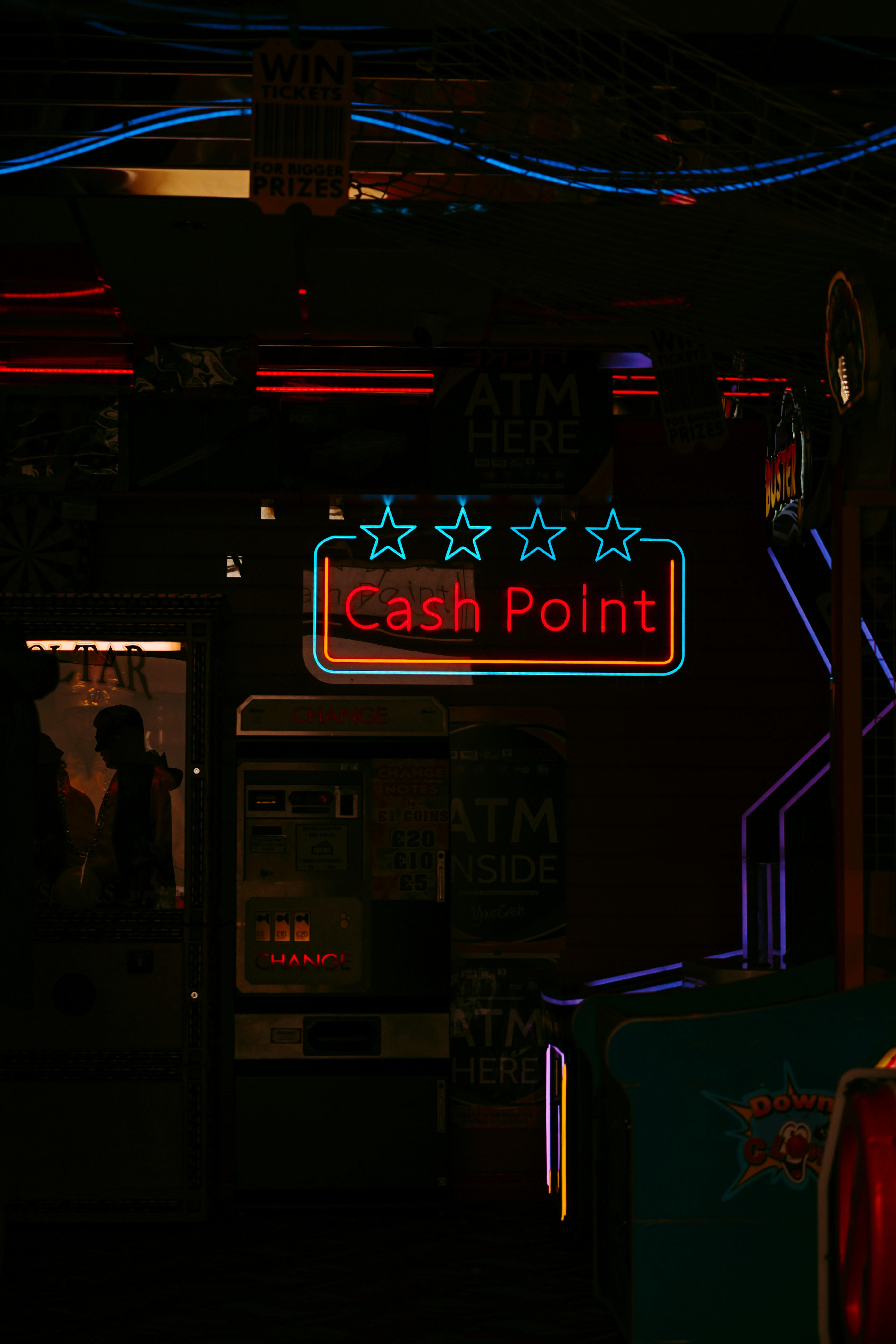 Neon signs illuminate a dark cash point.