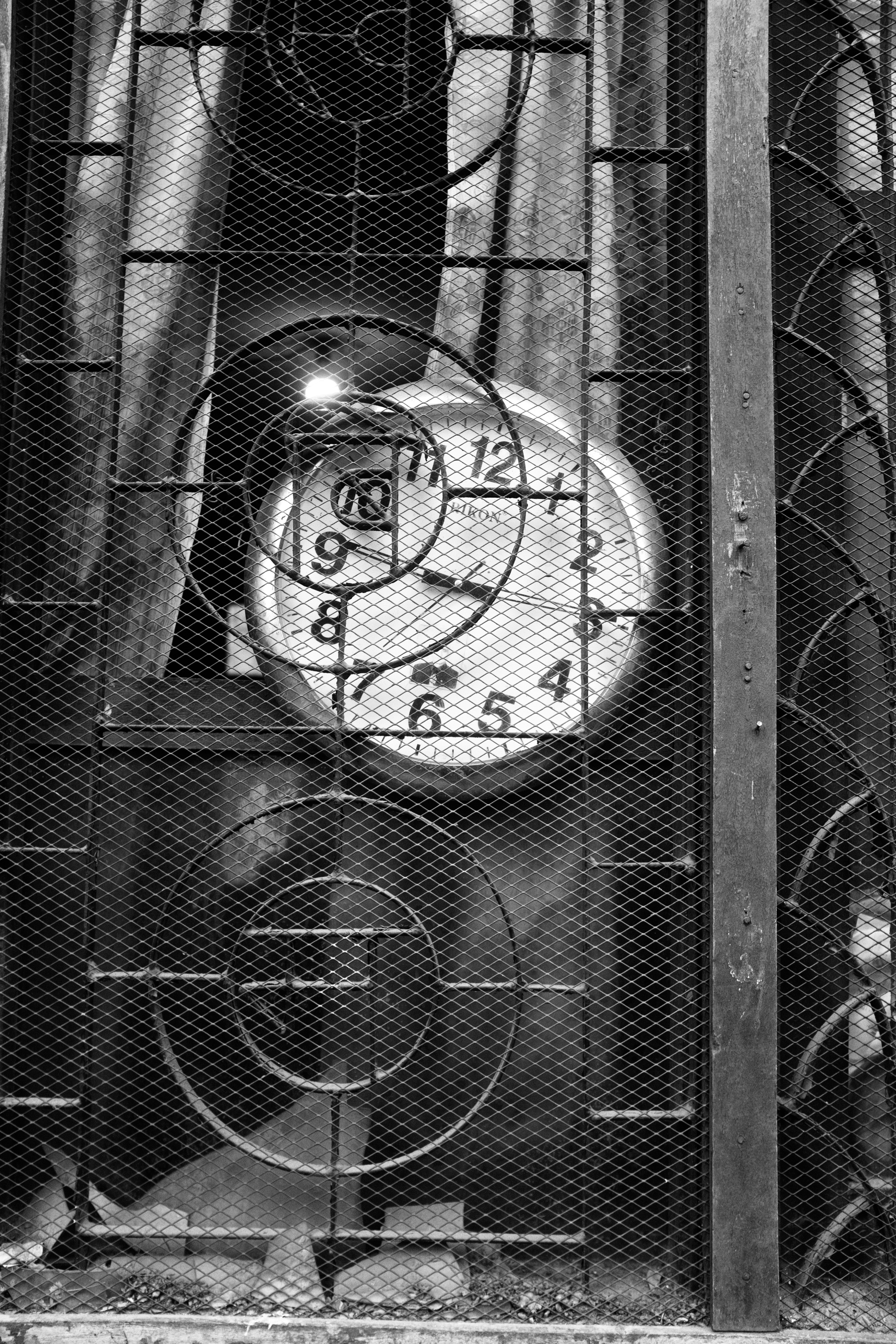 A clock is seen behind an intricate metal gate. photo – Free Vehicle ...