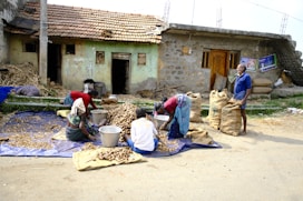 People are working outside of a simple village.