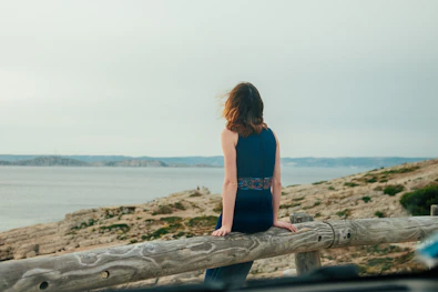 A woman sits, gazing out at a scenic view