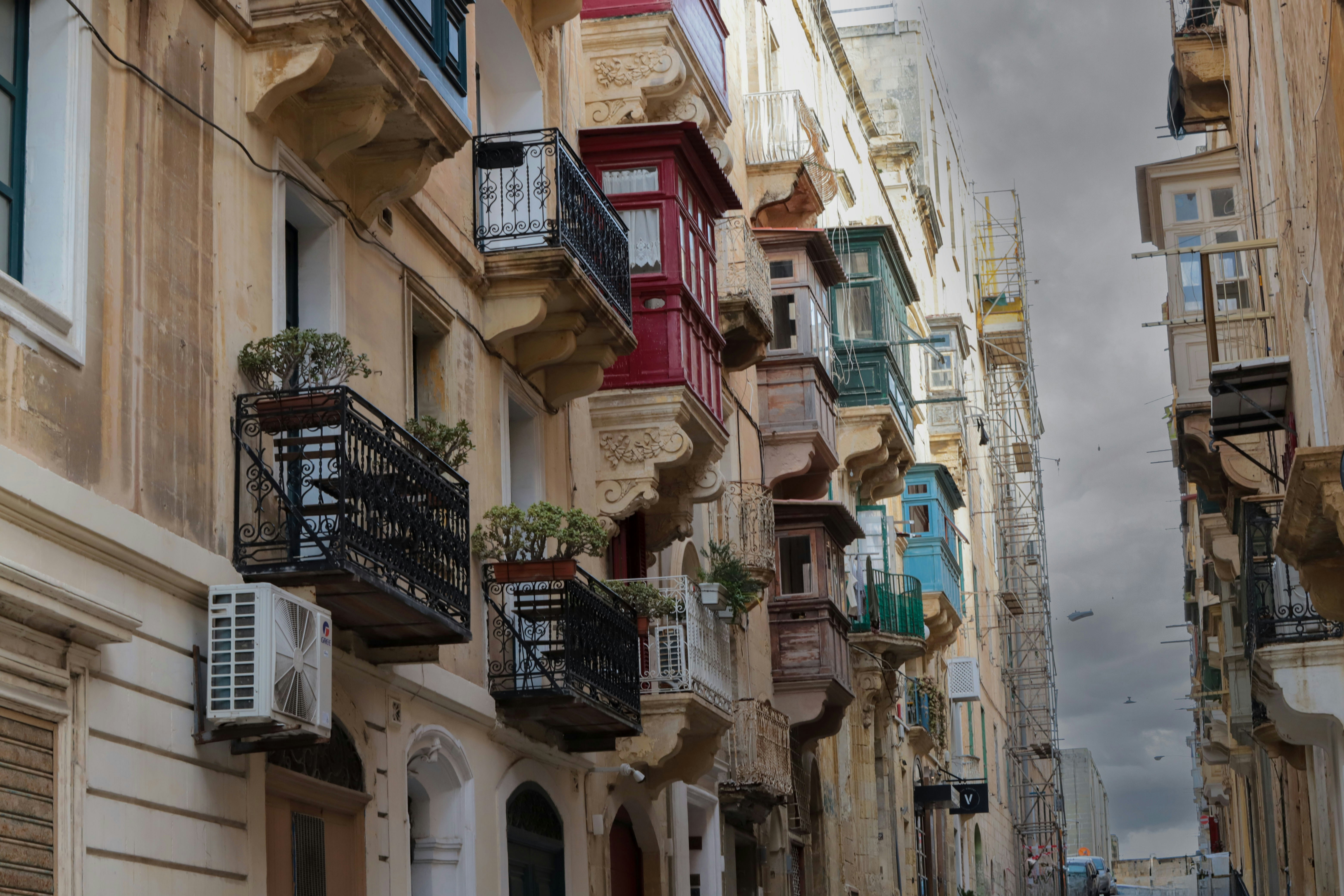 Buildings with balconies line a narrow street.