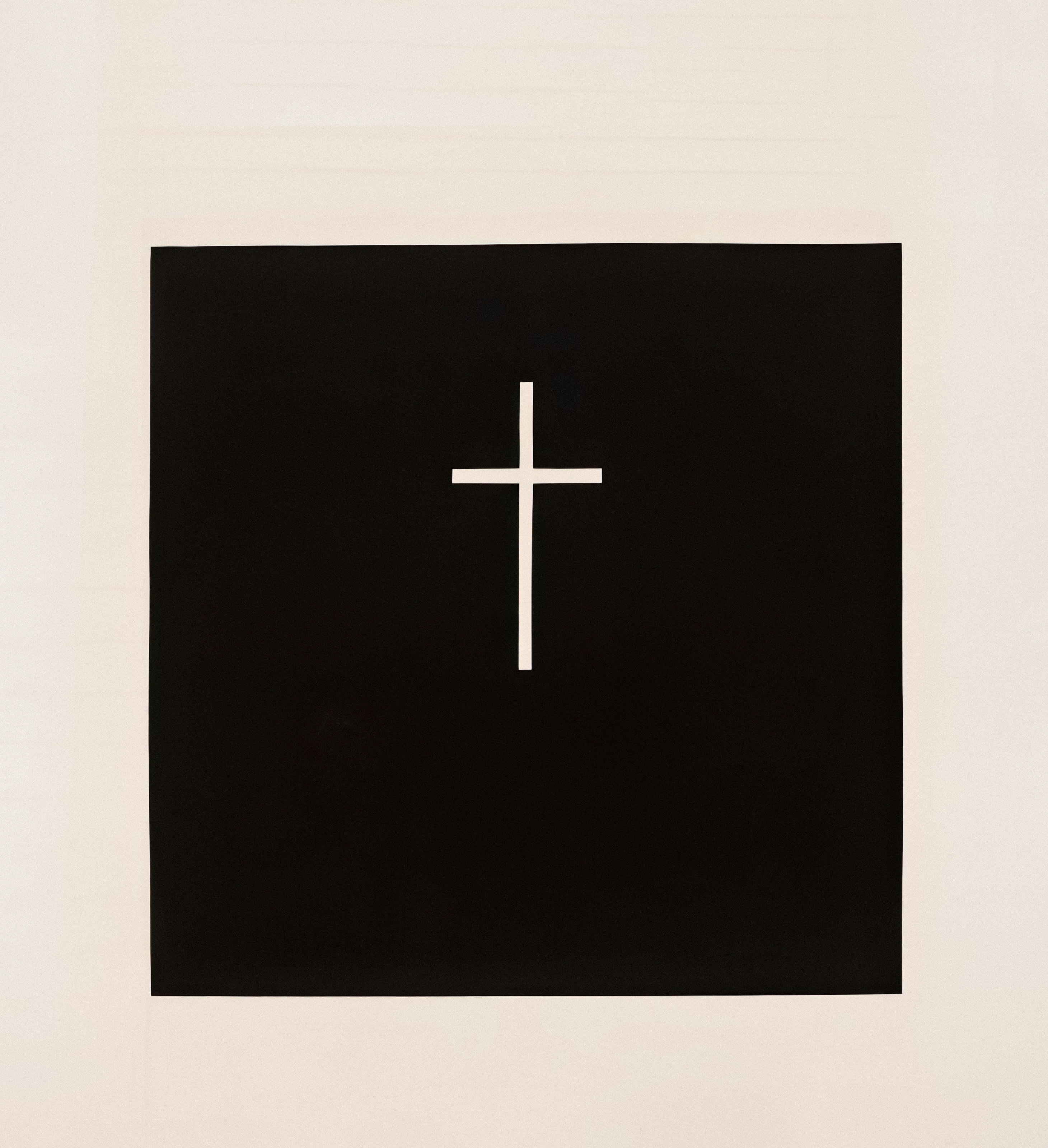 Ein weißes Kreuz auf schwarzem Grund mit cremefarbenem Rand.