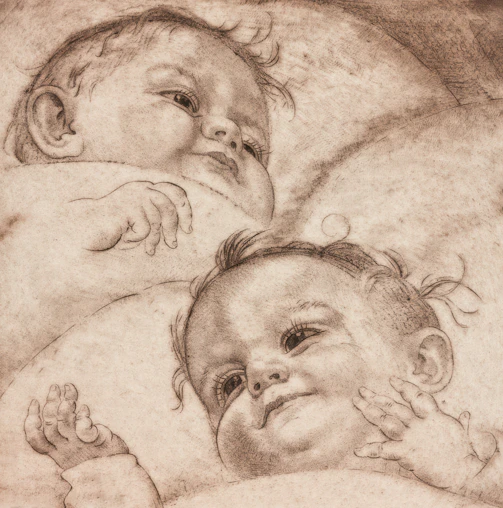 Two babies resting on a soft surface