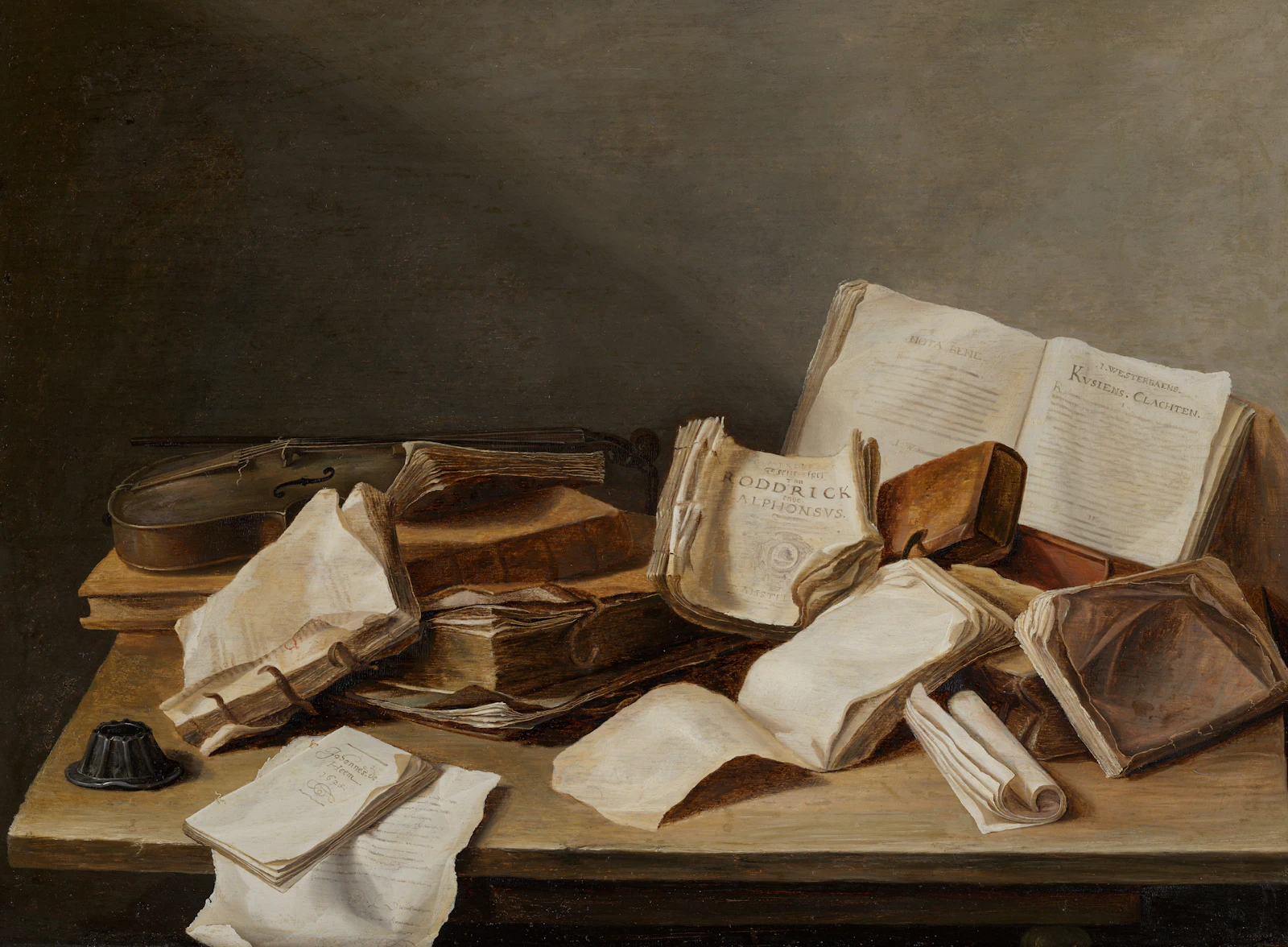 Worn books, loose papers and a violin piled on a wooden table.