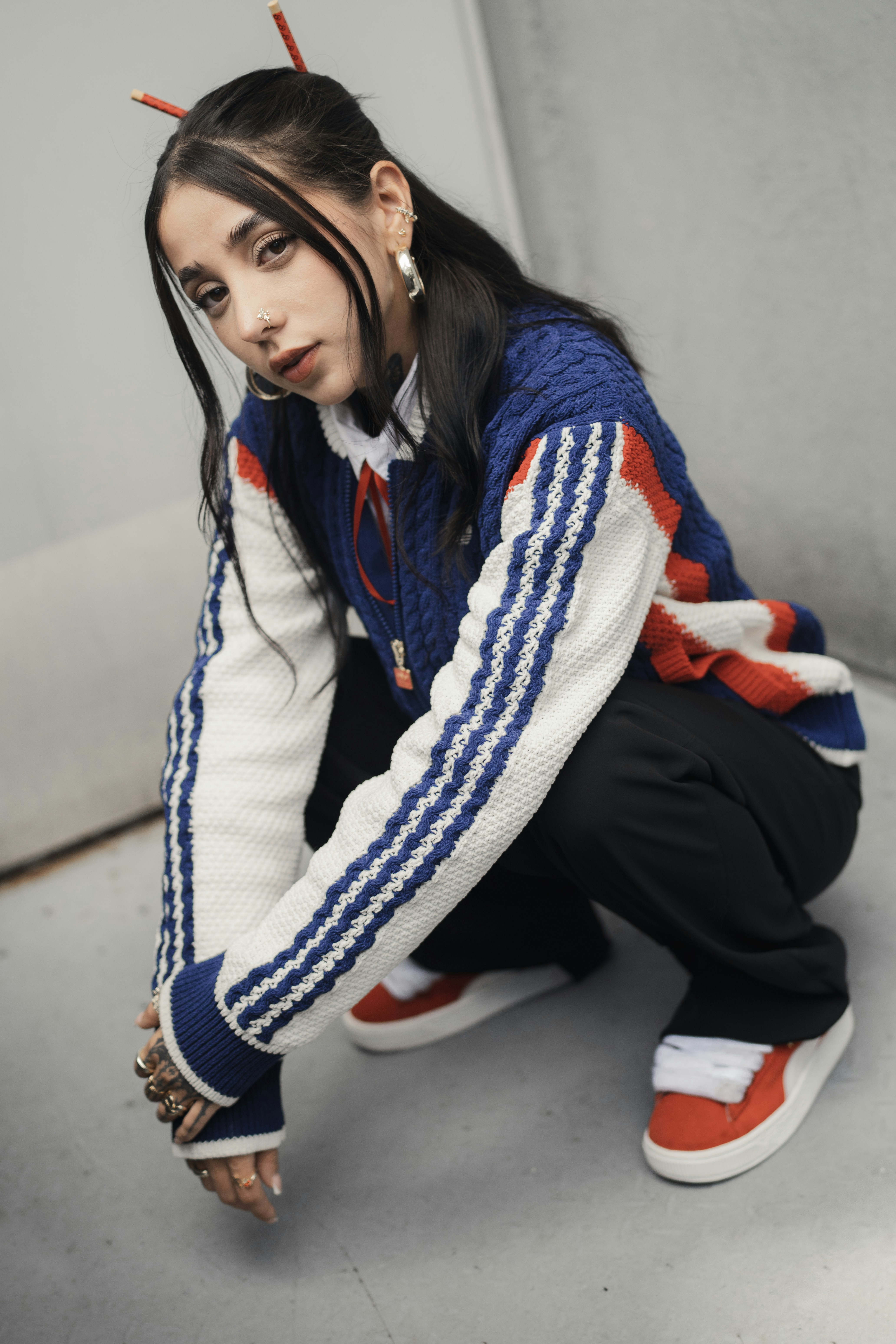 A stylish woman poses in fashionable attire.