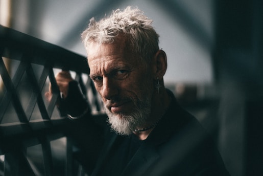 An older man stares intensely at the camera.