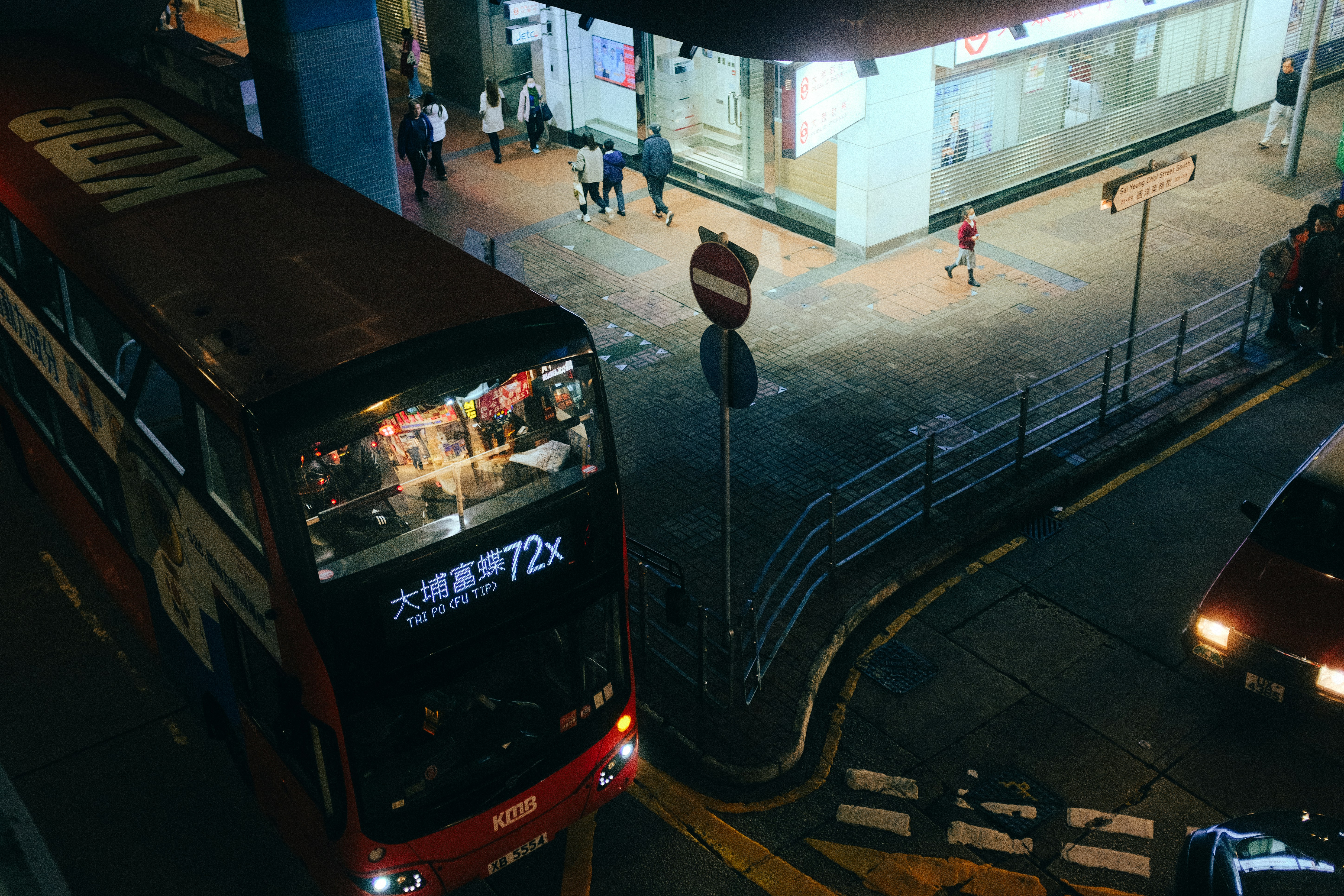 A double-decker bus sits in a city at night.