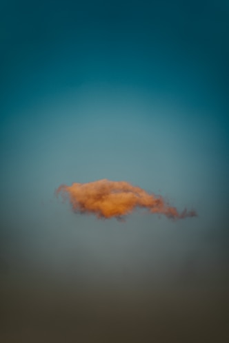 A single, orange cloud floats in the sky.