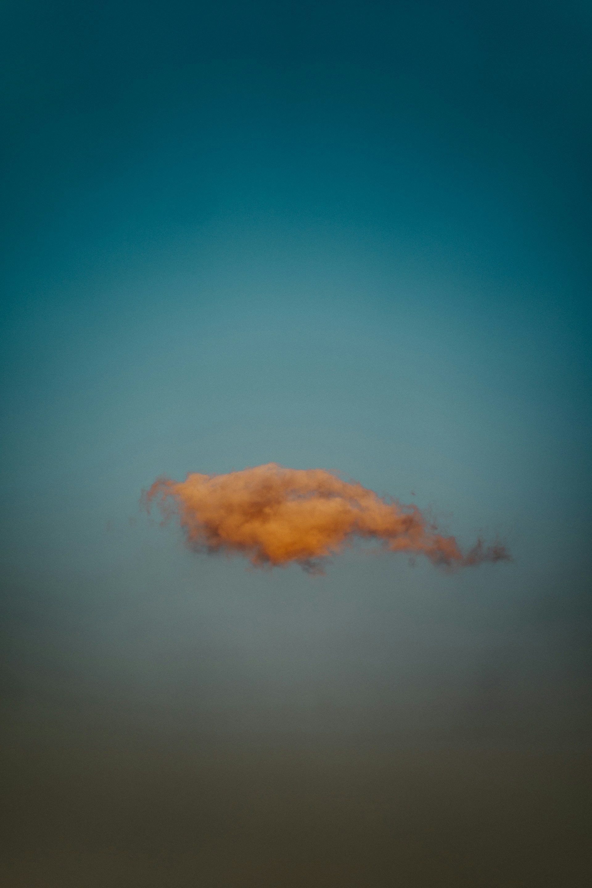 A single, orange cloud floats in the sky.