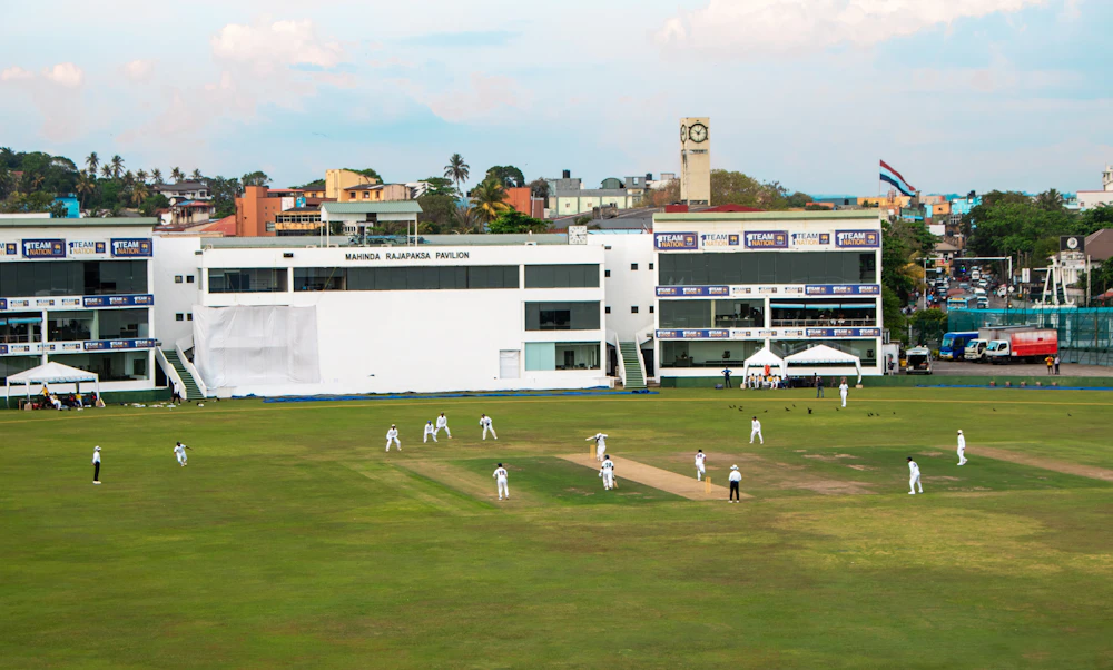 Cricket match in progress on a large green field