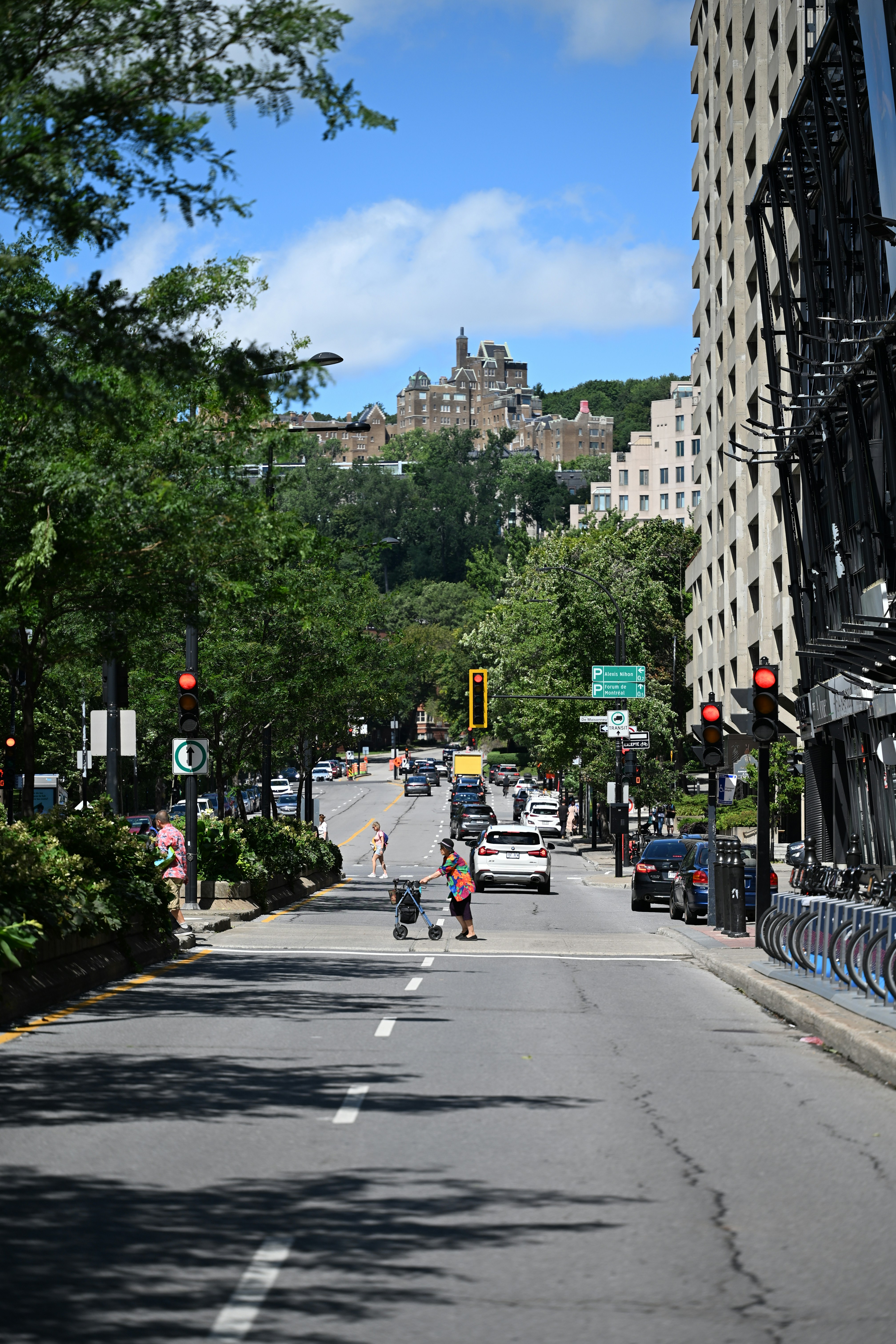 A city street leads to a building on a hill.
