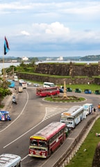 Buses and traffic near a fort by the ocean.