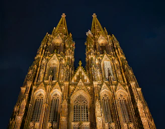 Cologne cathedral illuminated at night with a low angle view.