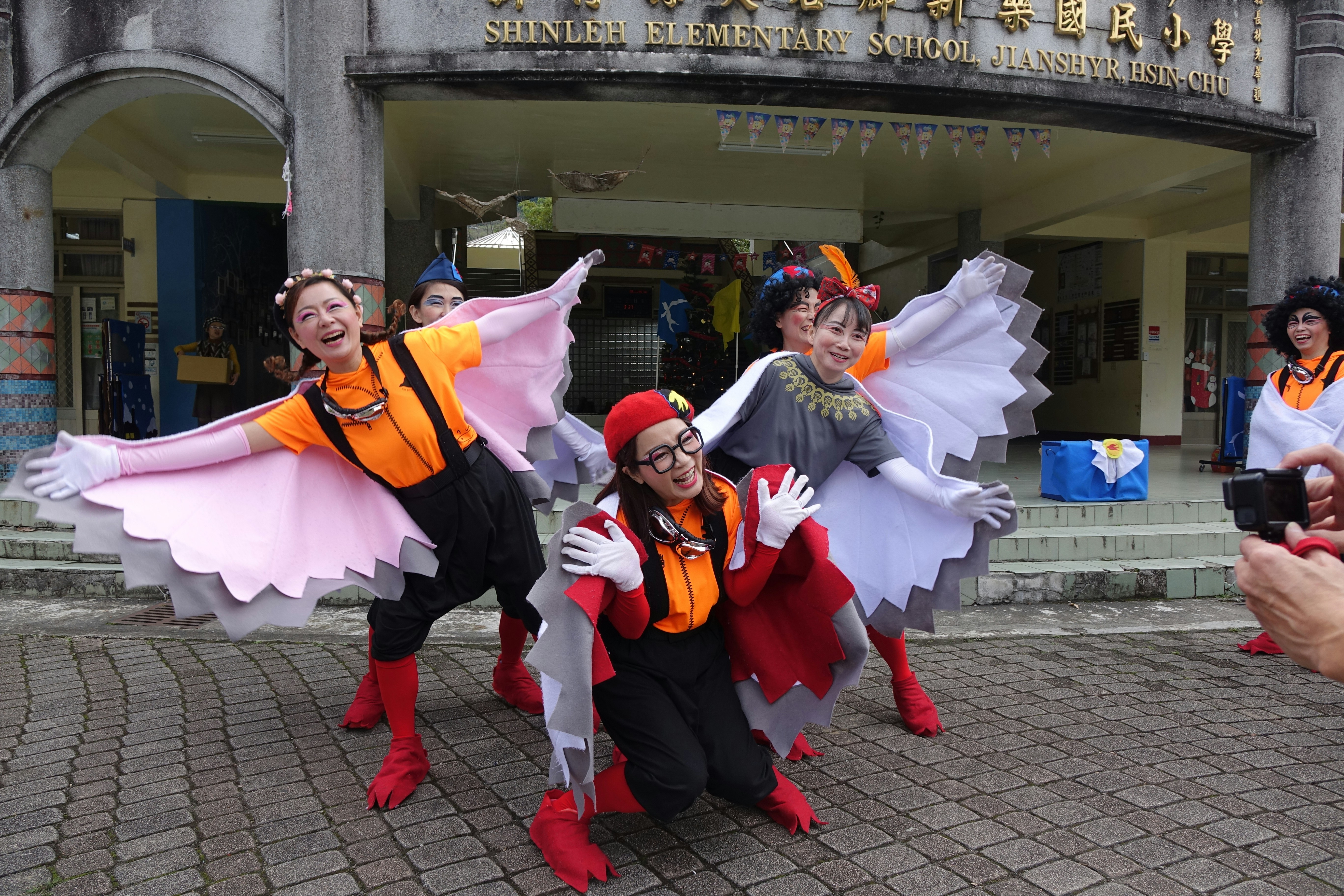 Orang-orang dengan kostum burung berpose untuk foto.