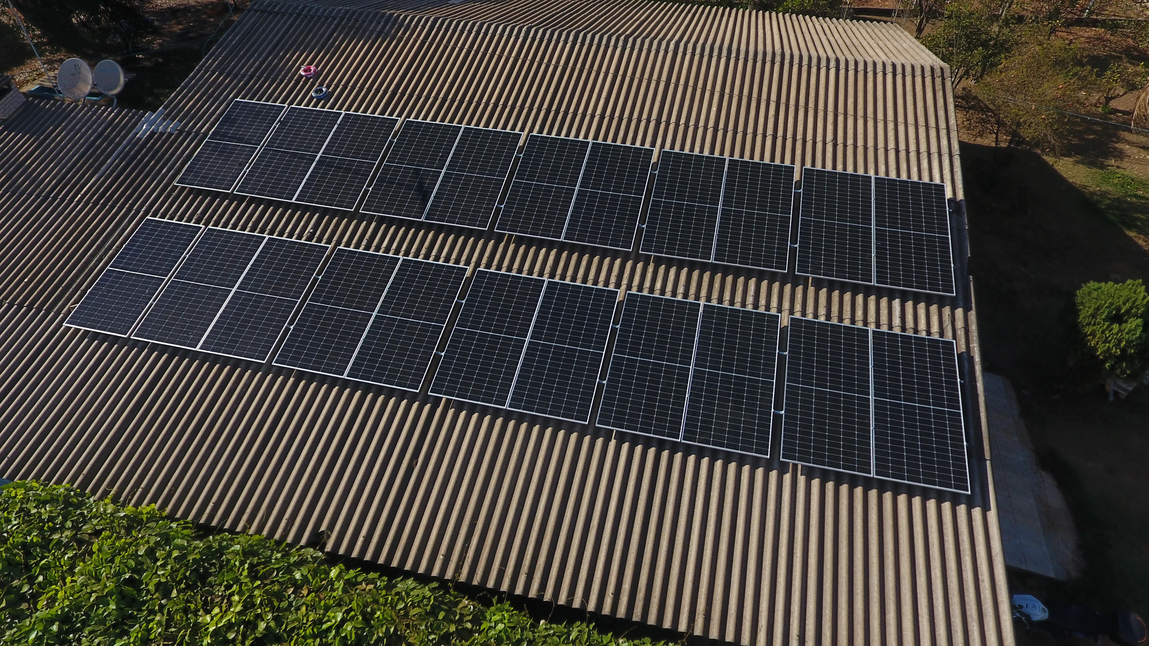 Rows of solar panels installed on a large industrial sheet roof (representative image)