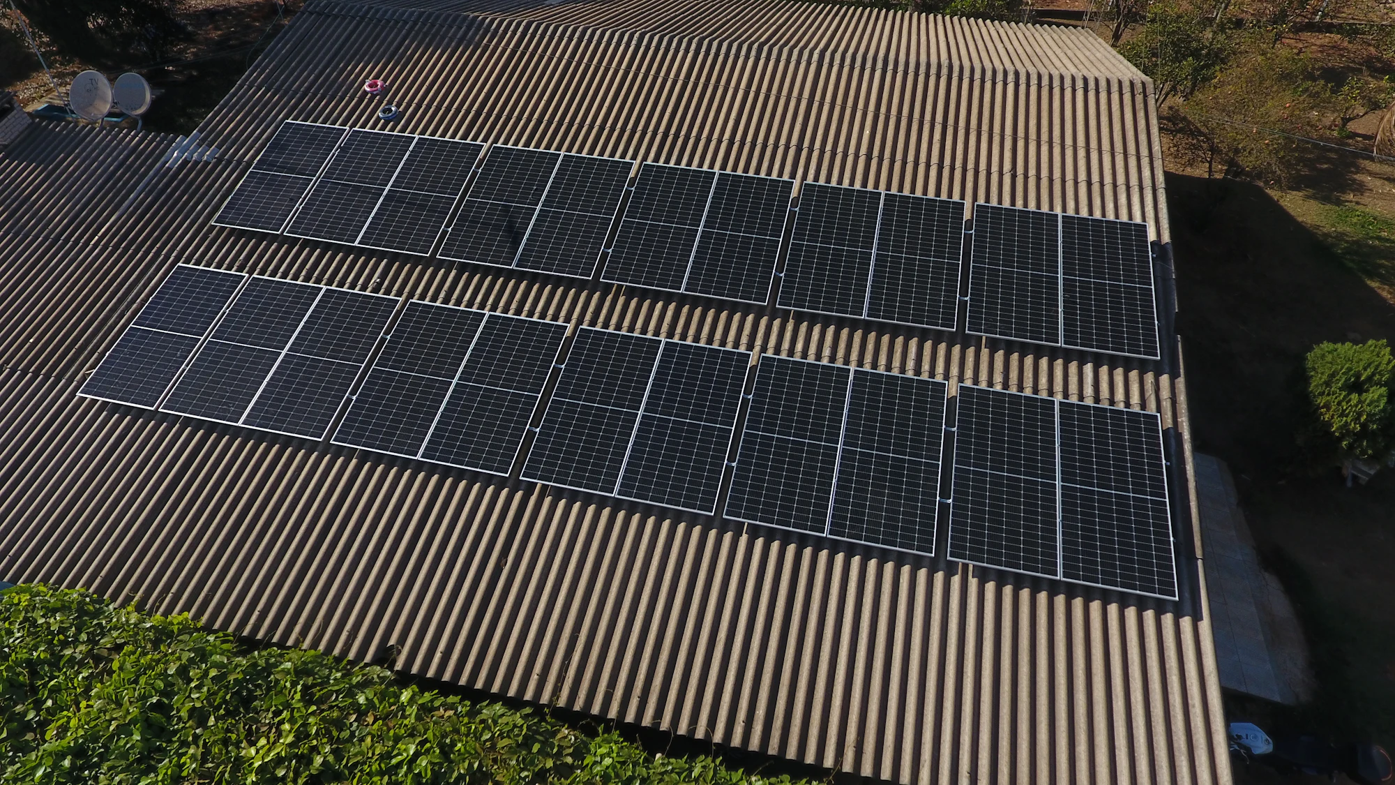 Technician installing a solar panel on a rooftop