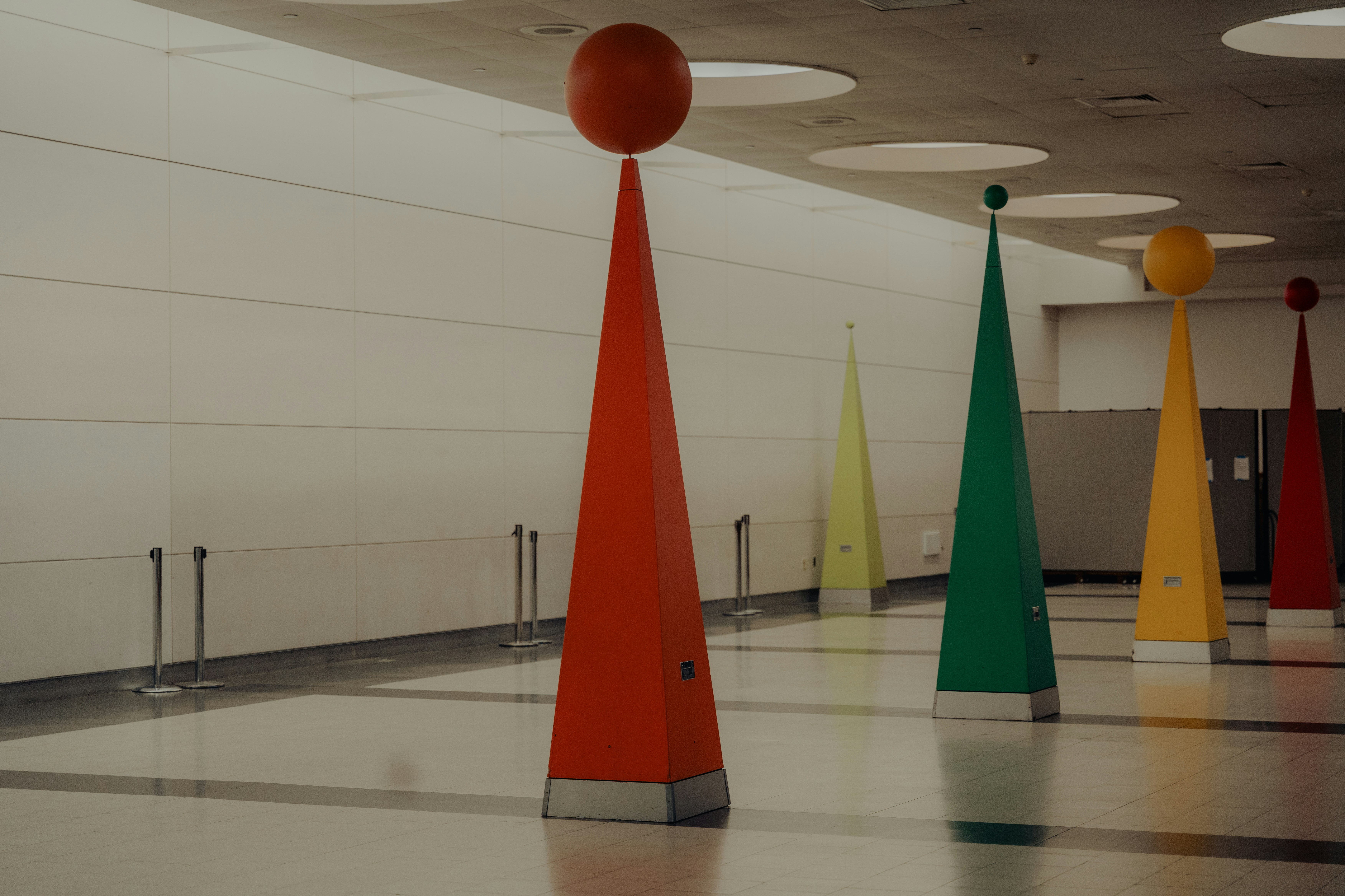 Colorful geometric sculptures line a hallway.