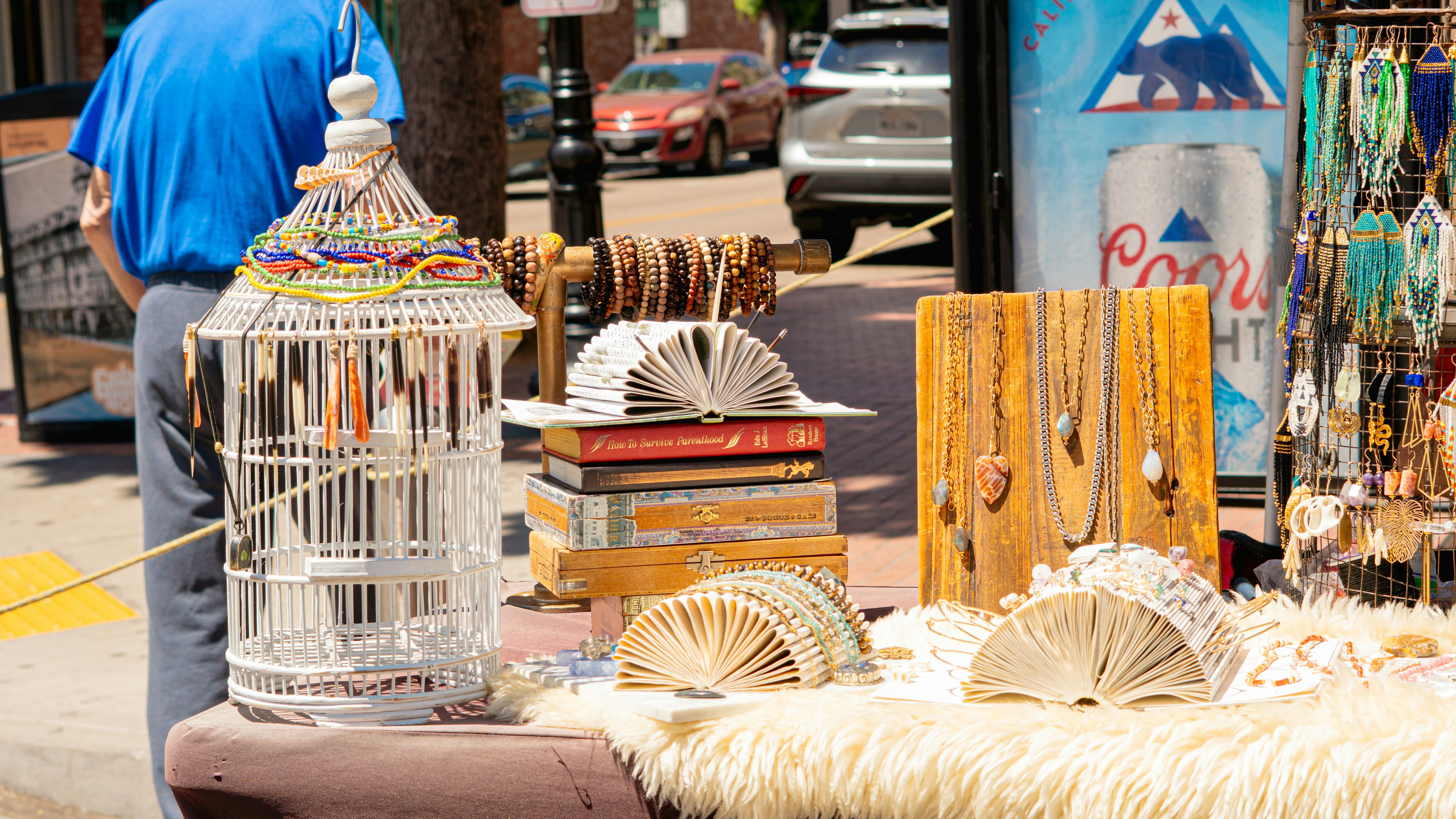 A street vendor sells crafts and jewelry.