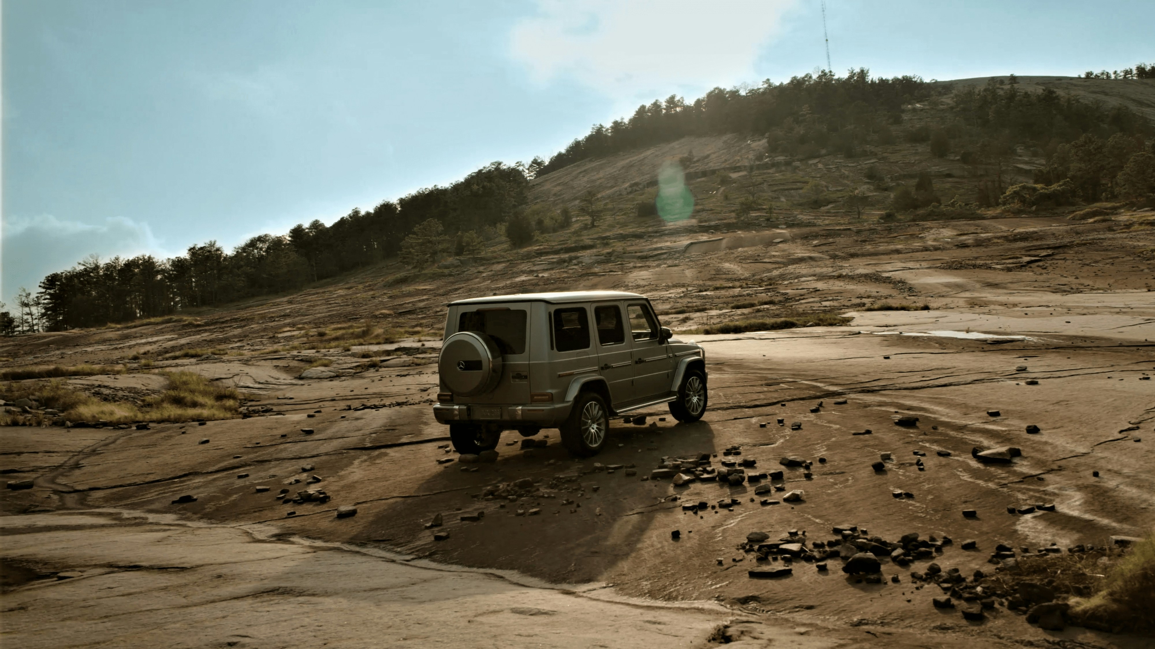 An suv is off-roading on a rugged landscape.