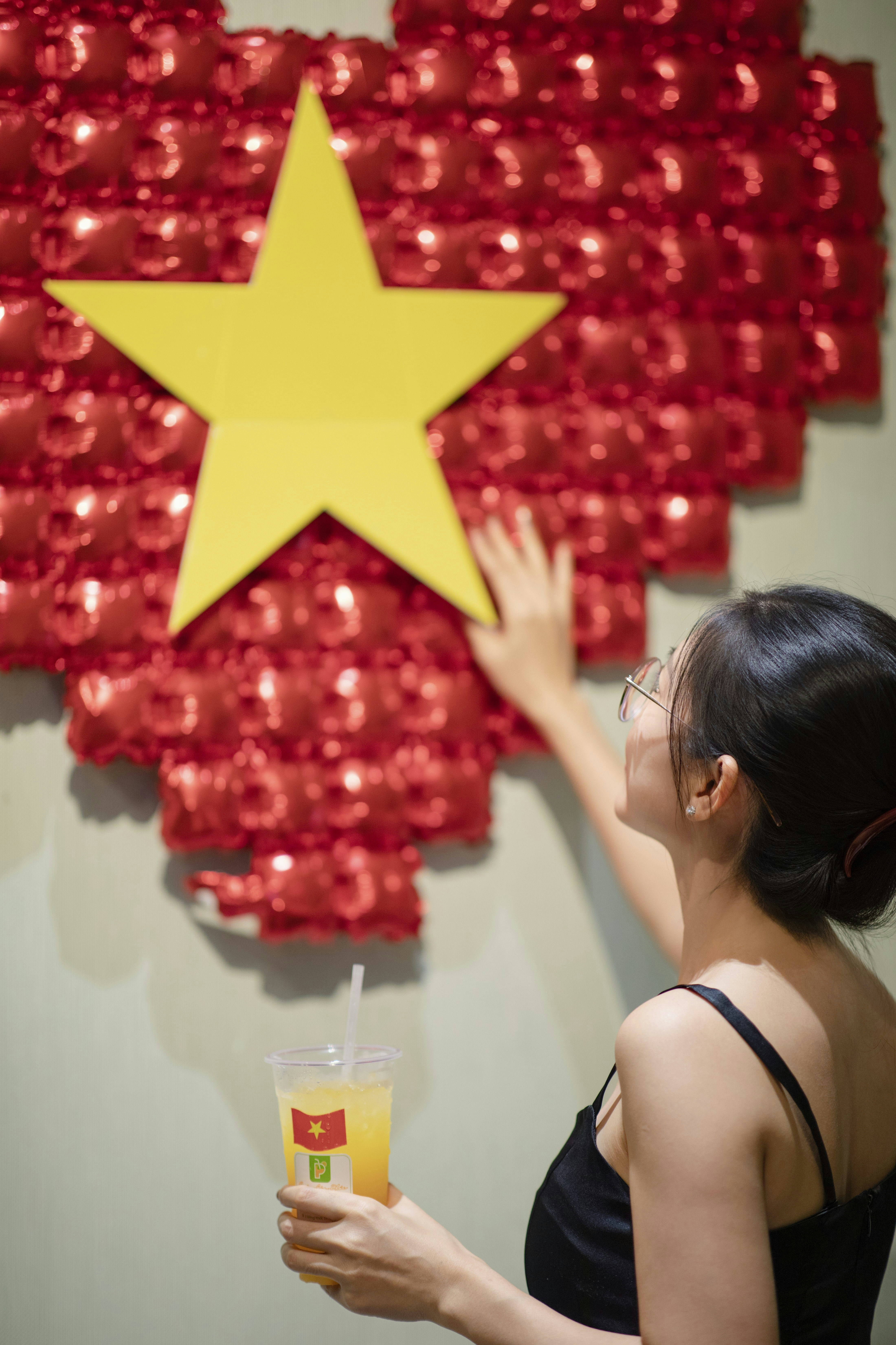 Woman touches the vietnamese flag art piece.