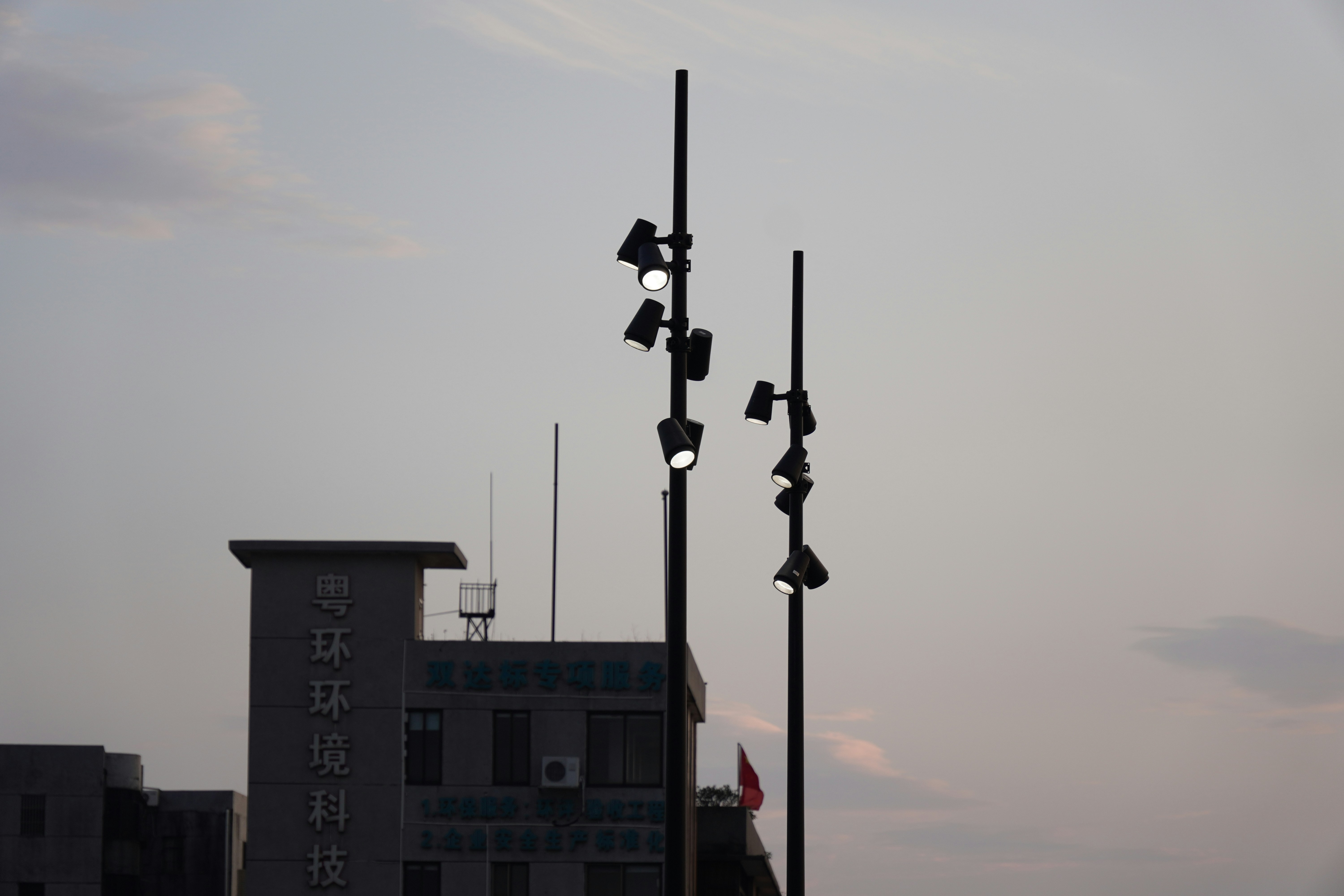 Lights stand tall against a dusky sky.