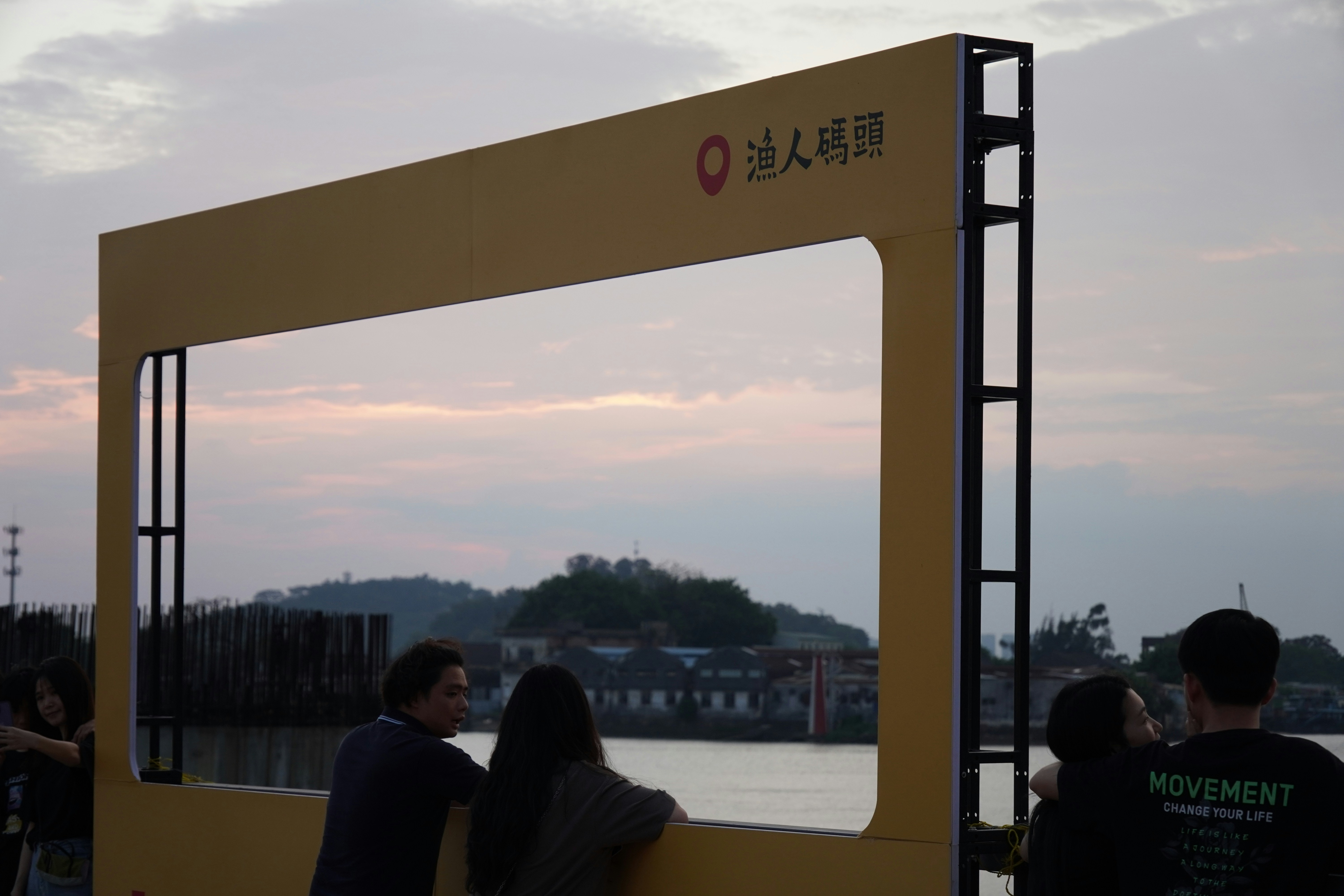 People look through a frame at a river