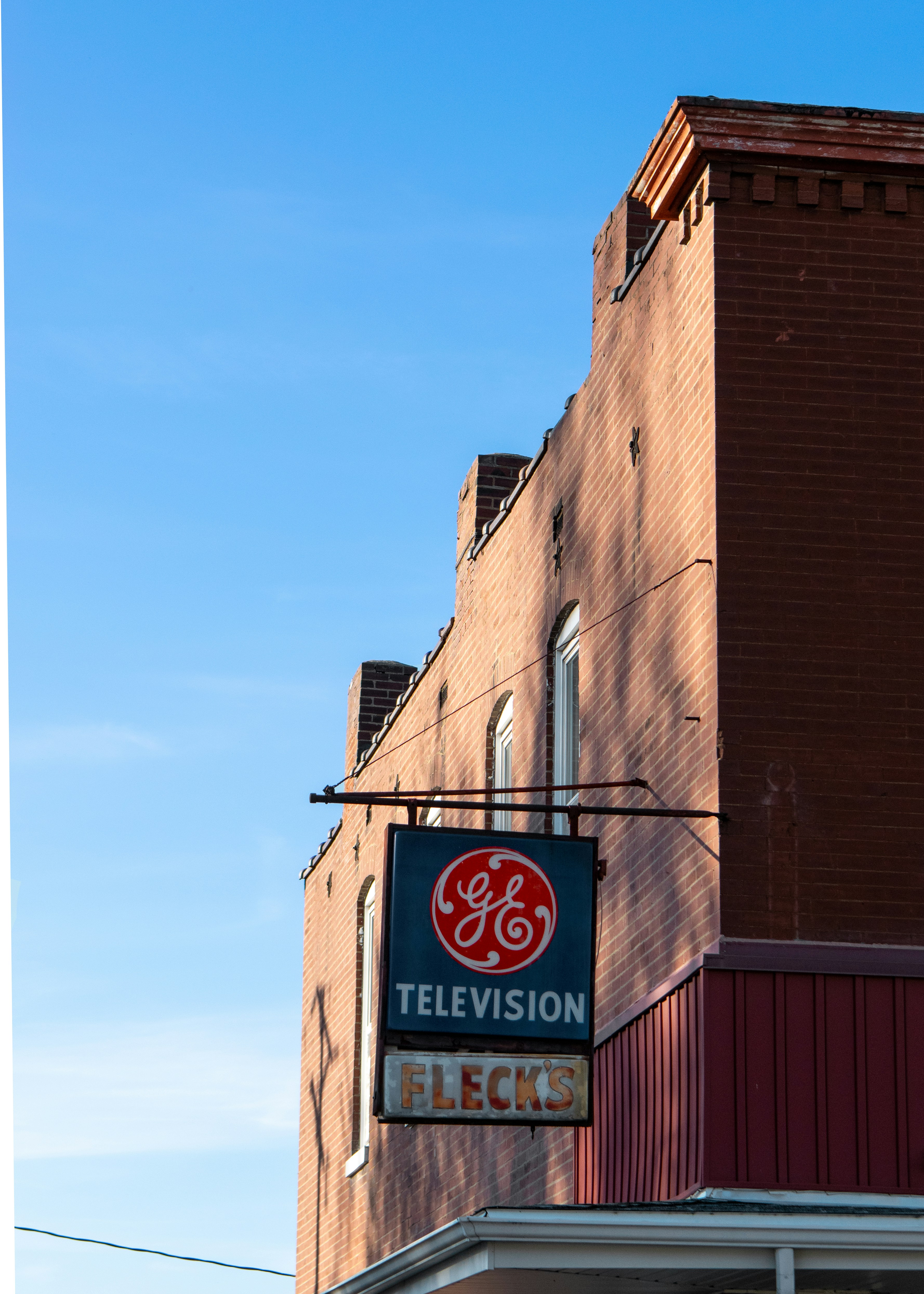 Vintage ge television sign on a brick building.