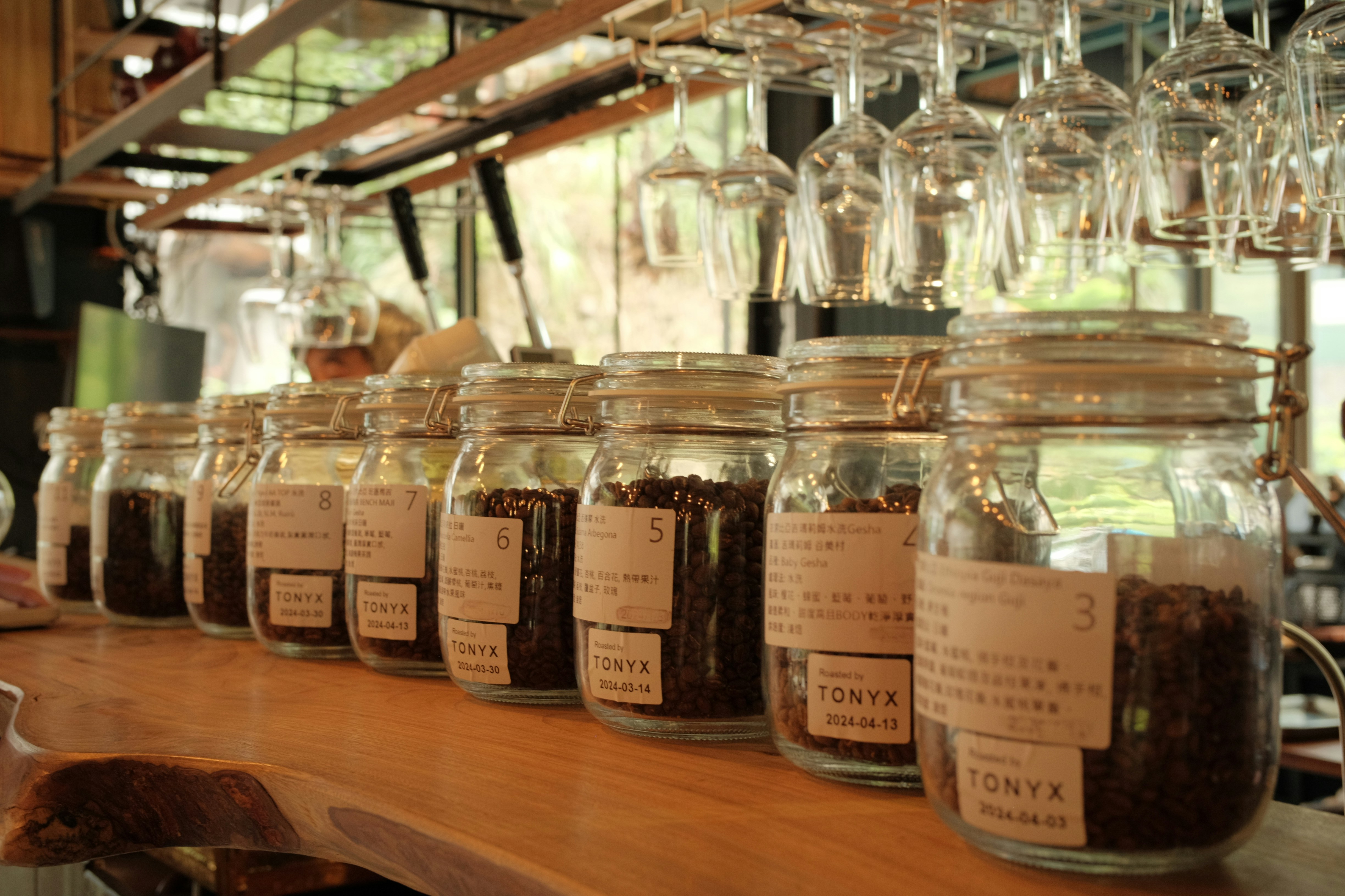 Coffee beans are displayed in jars at a coffee shop.