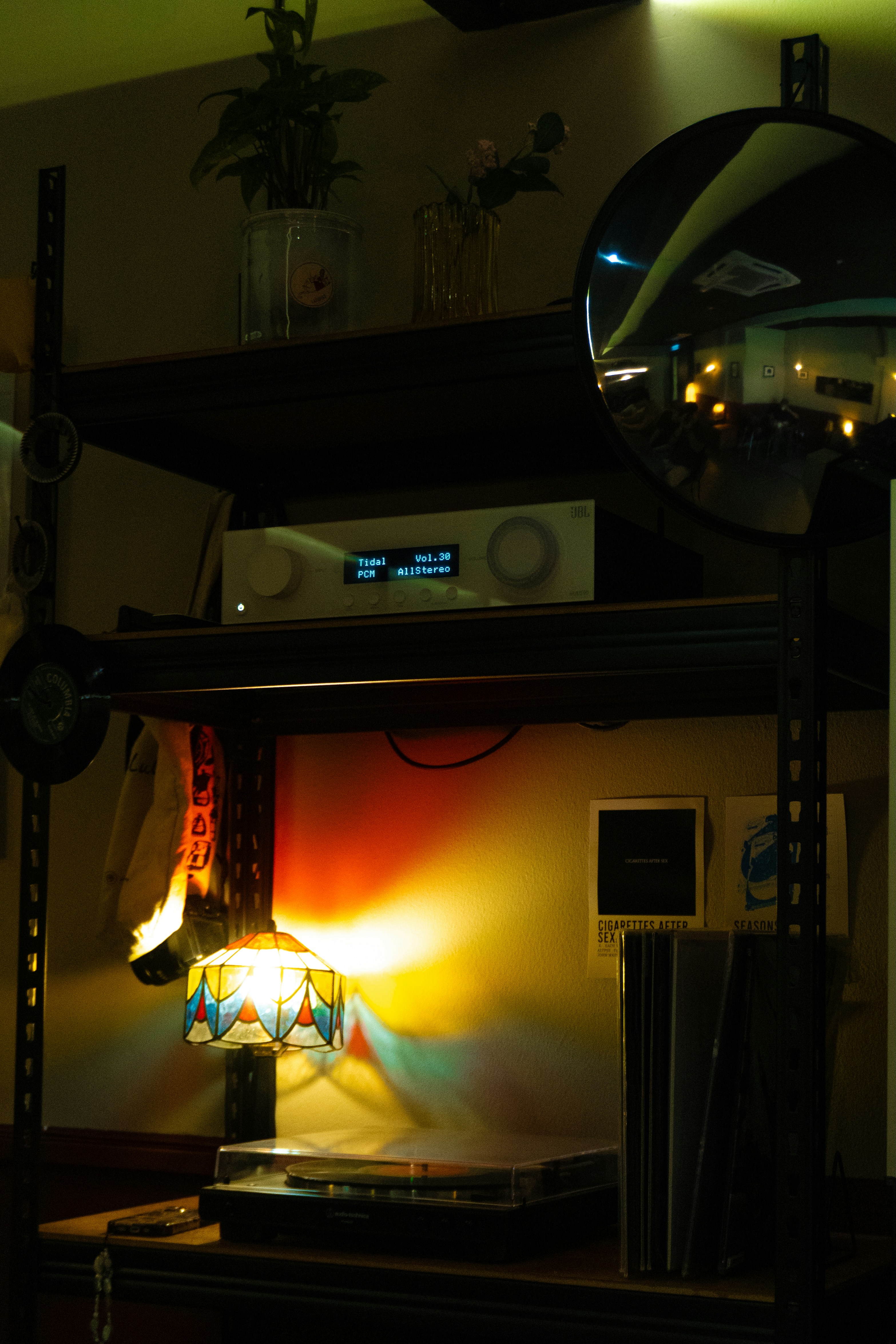 A cozy room features a stereo and colorful lamp.