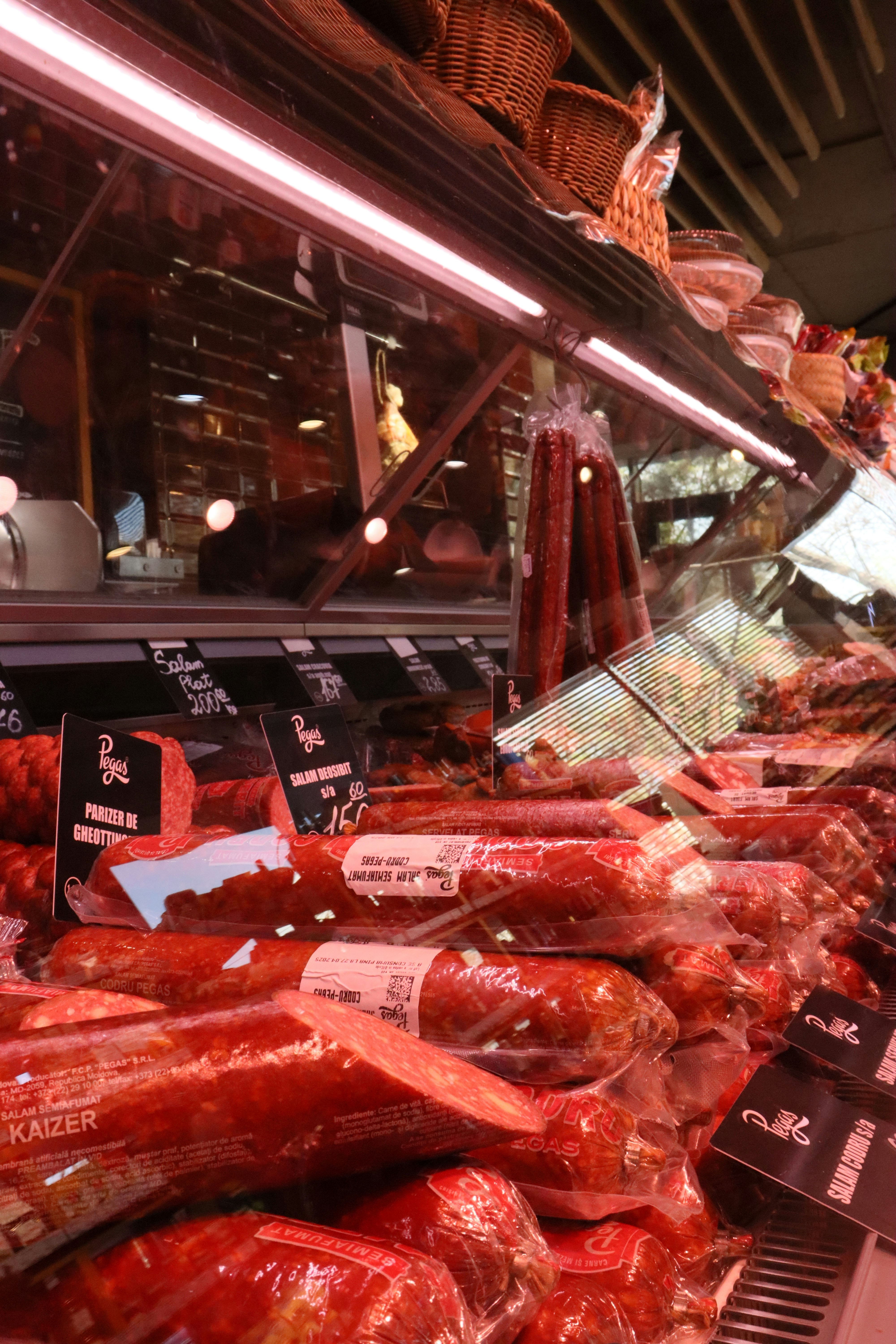 Fresh meats are displayed in a deli case.