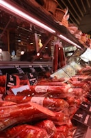 Fresh meats are displayed in a deli case.